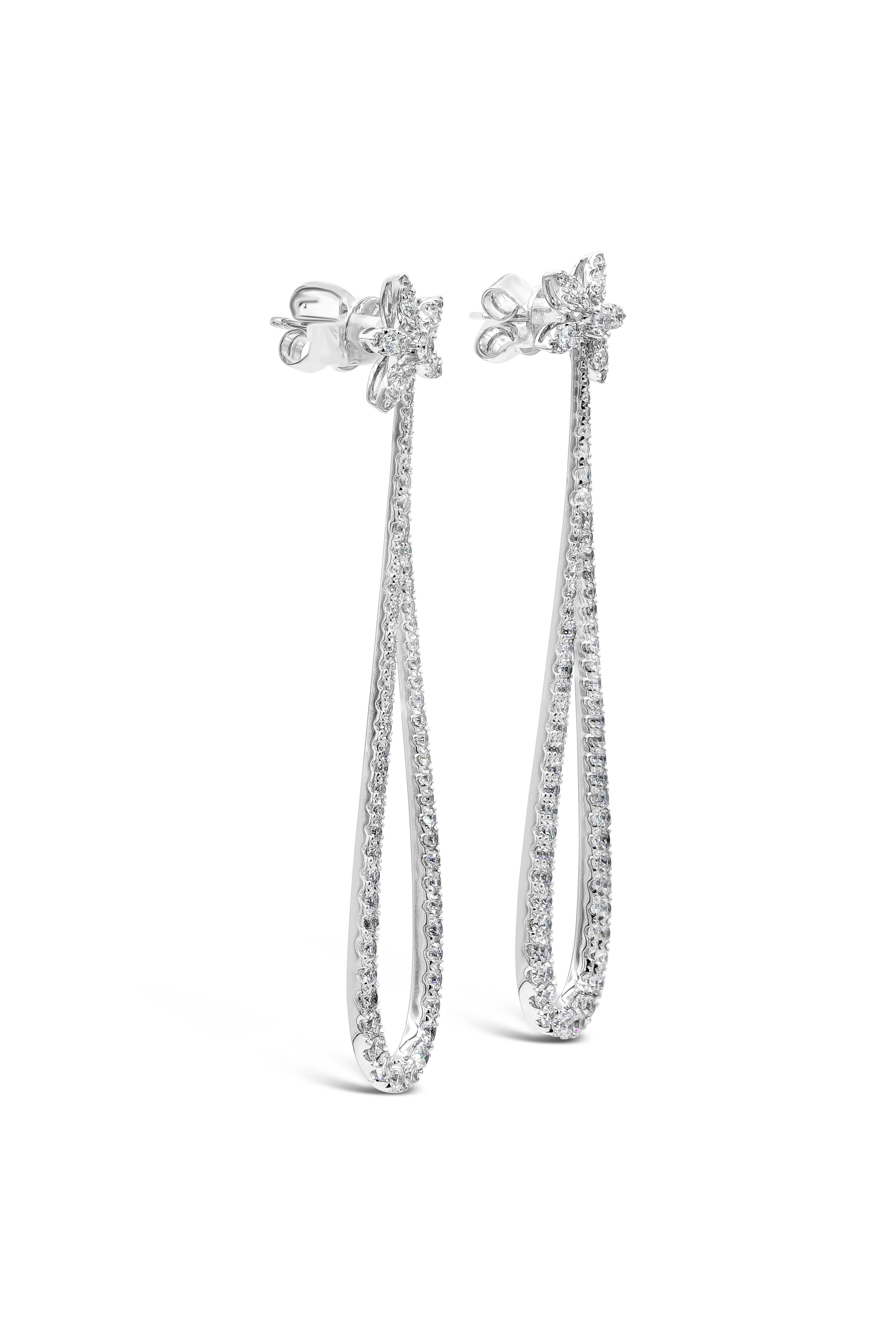 A fashionable style of dangle earrings showcasing a row of round brilliant diamonds set in an open-work tear drop dangle design and suspended on a round diamonds set in a floral-motif design. Finely made in 18k white gold and Diamonds weigh 2.34