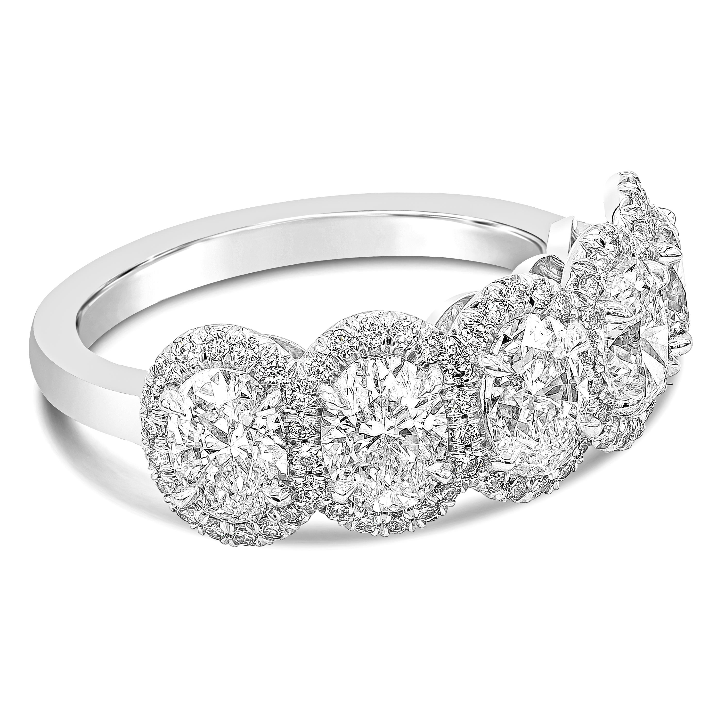 A classic and brilliant wedding band featuring five oval cut diamonds weighing 2.63 carats total, G color, VS in clarity. Set in a platinum four prong basket setting and each oval cut diamonds are surrounded by brilliant round diamonds weighing 0.38