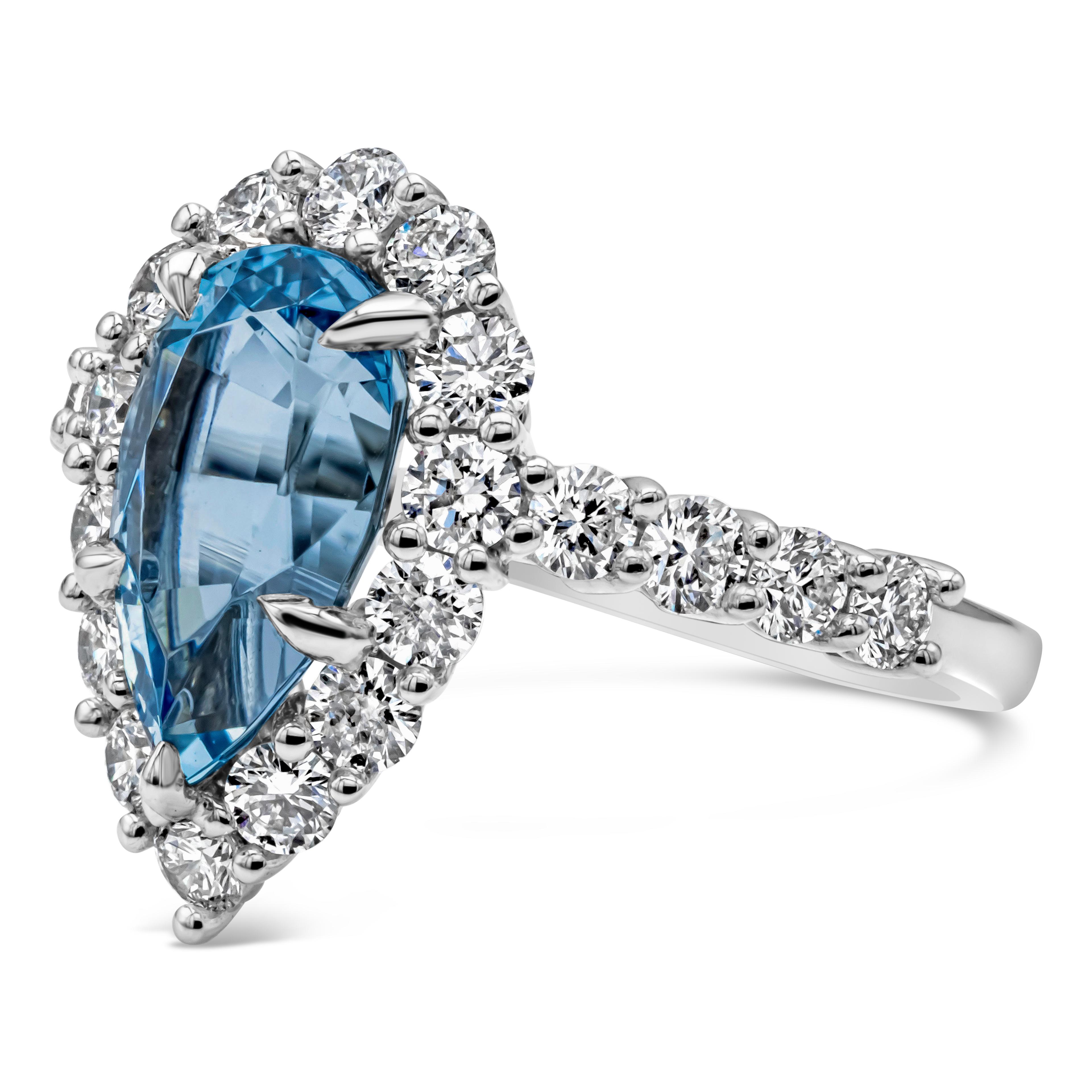 A simple and timeless halo engagement ring showcasing pear shape blue aquamarine weighing 2.45 carat total. Surrounded and accented by brilliant round diamonds in a halo design and half way down the band. Diamonds weigh 1.32 carats total, F Color VS