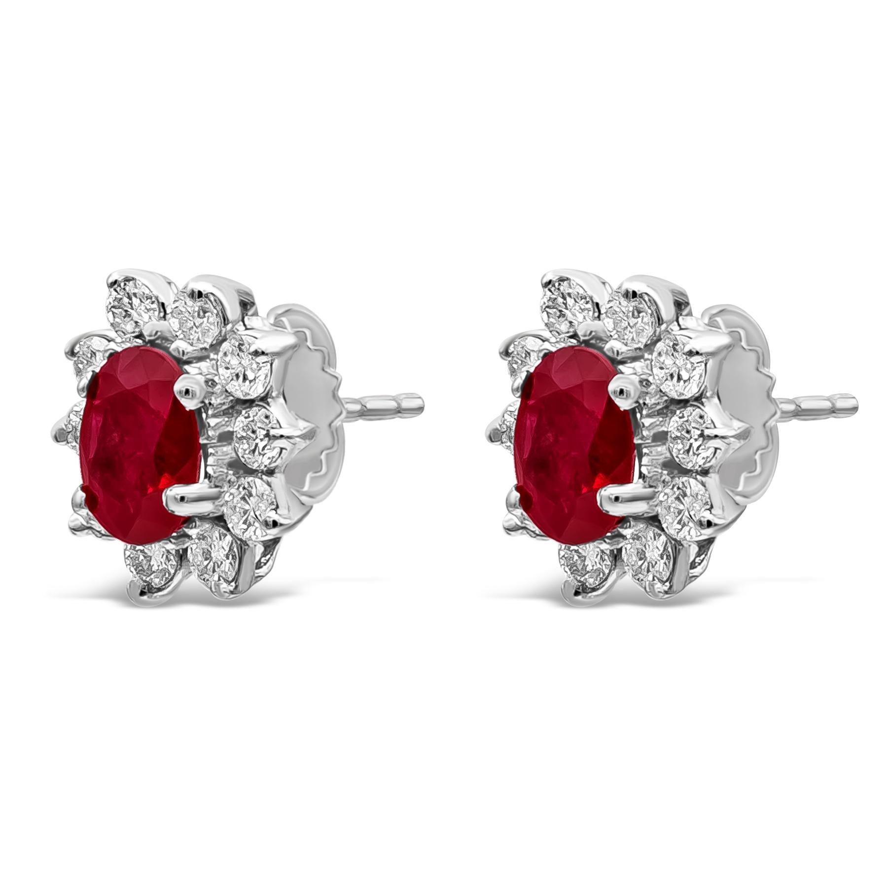 Une paire de boucles d'oreilles classiques au motif floral mettant en valeur des rubis ovales d'un poids total de 2,64 carats. Entouré d'une seule rangée de diamants ronds de taille brillant pesant 1 carat au total. Fabriqué avec de l'or blanc