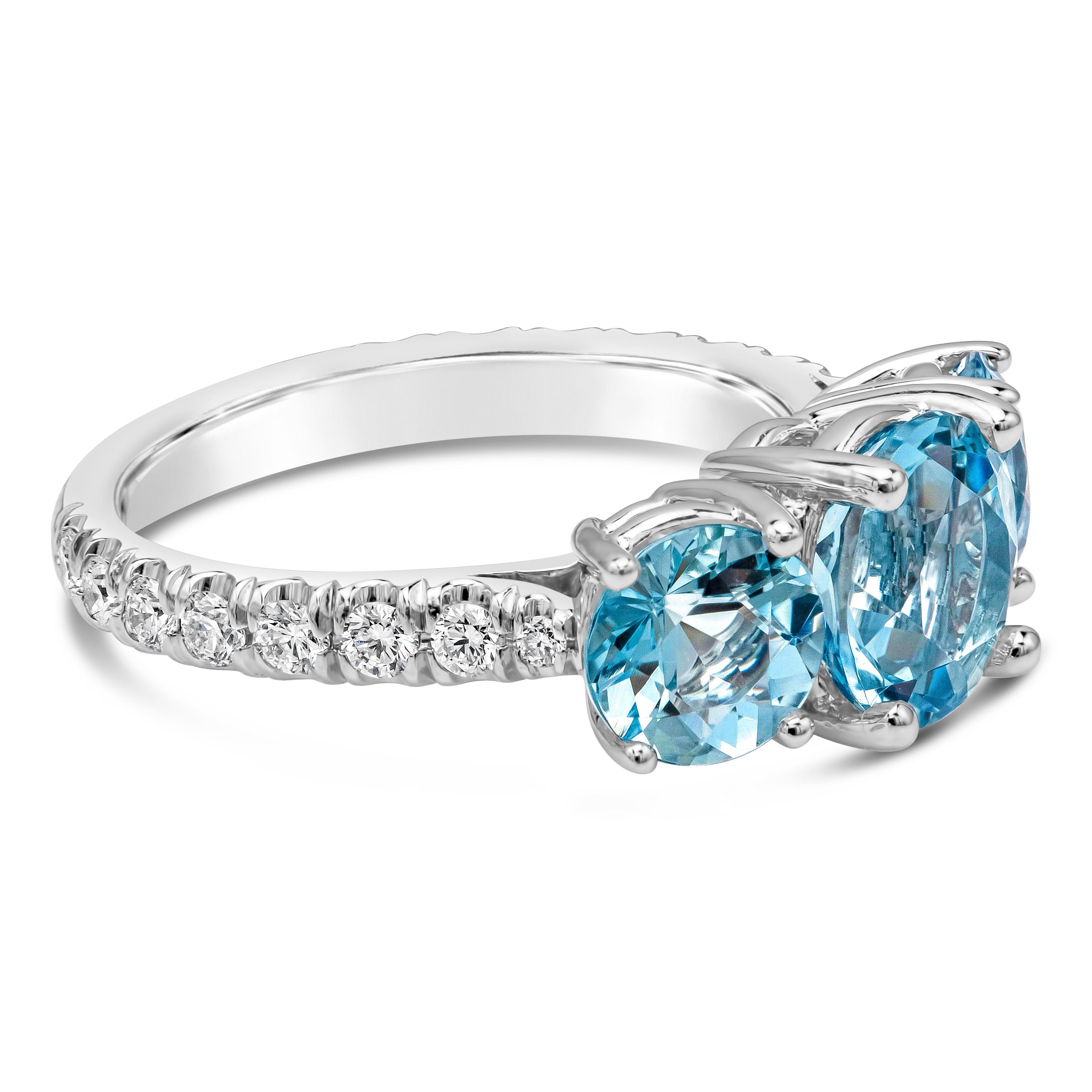 A gorgeous three stone gemstone engagement ring features three round cut blue aquamarine weighing 2.94 carats total VS-VVS in Clarity, set in a classic four prong basket setting. Shank is diamond encrusted in half eternity setting. Diamonds weigh