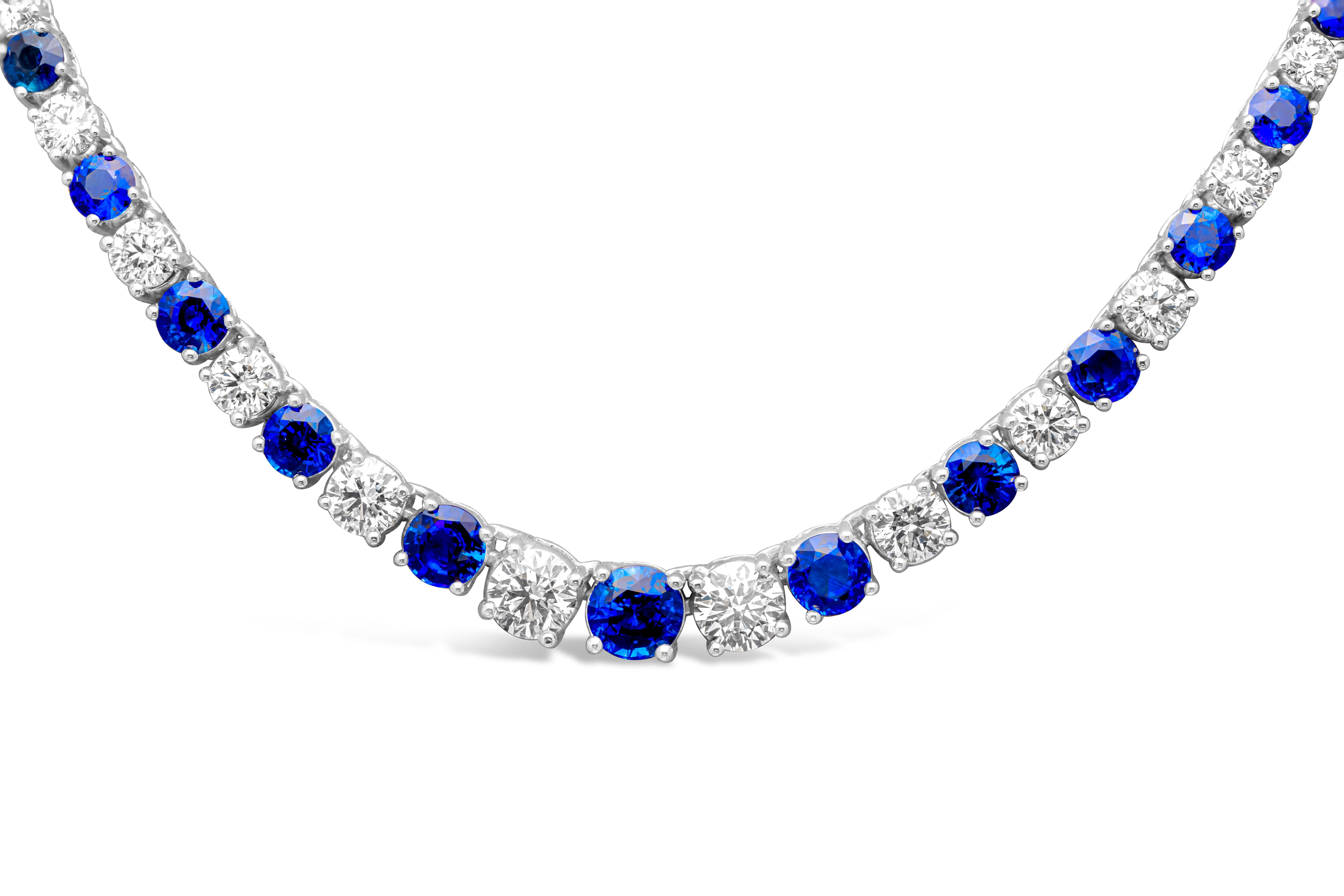 Luxurious and elegantly made riviere tennis necklace showcasing brilliant round blue sapphires and diamonds that elegantly alternate with each other and get larger to the center of the necklace. Set in a classic four prong basket setting. Blue