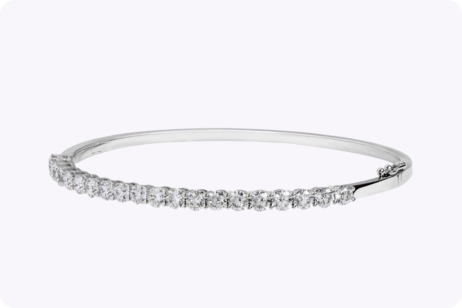 Sparkle in the spotlight with this diamond bangle bracelet. Features 20 full-cut round diamonds each elegantly set in an 18K white gold basket. Diamonds weigh 3.12 carats total. A hinged design bracelet for easy wear and removal. Made in 18k white