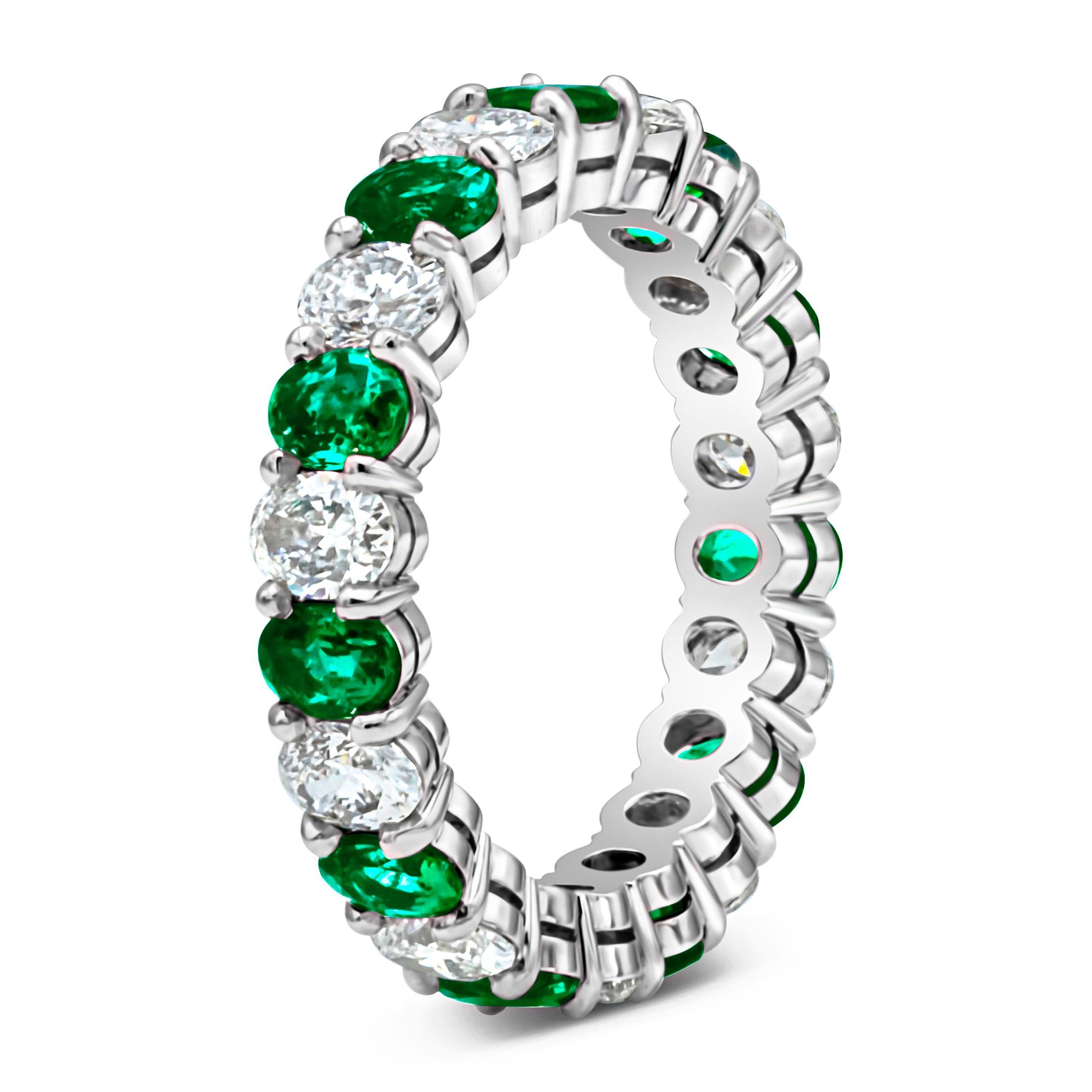 This classy and stunning wedding band showcasing alternating oval cut green emerald weighing 1.56 carats total brilliant round diamonds weighing 1.60 carats total, E-F color and VS-SI in clarity. Set in a shared two prong setting, made in