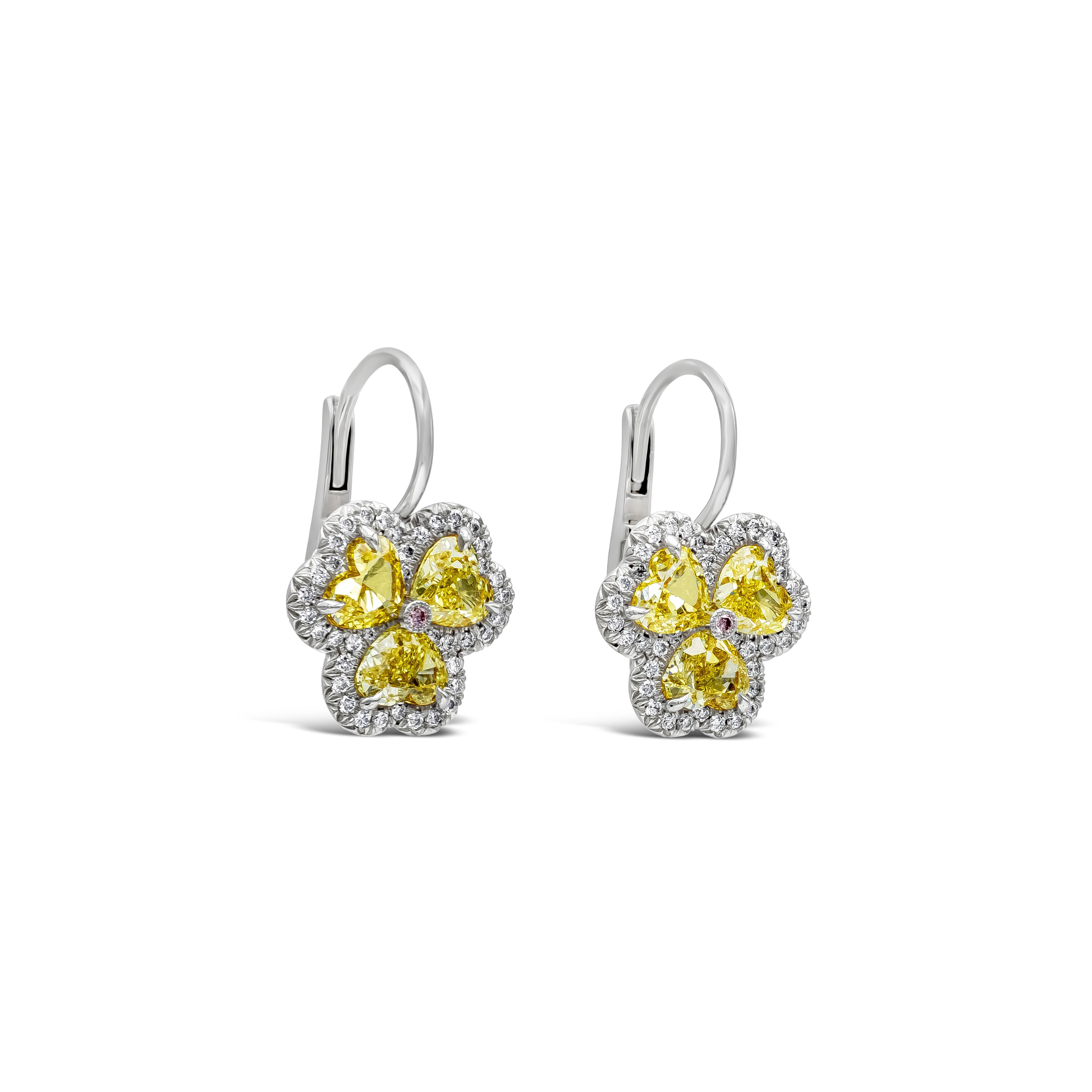 A simple yet beautiful fashion drop earrings showcasing 3 on each earring fancy intense yellow color heart shape cut diamonds weighs 3.20carats total, set in a clover designed setting. Each heart shape cut diamonds is accented by a single row of