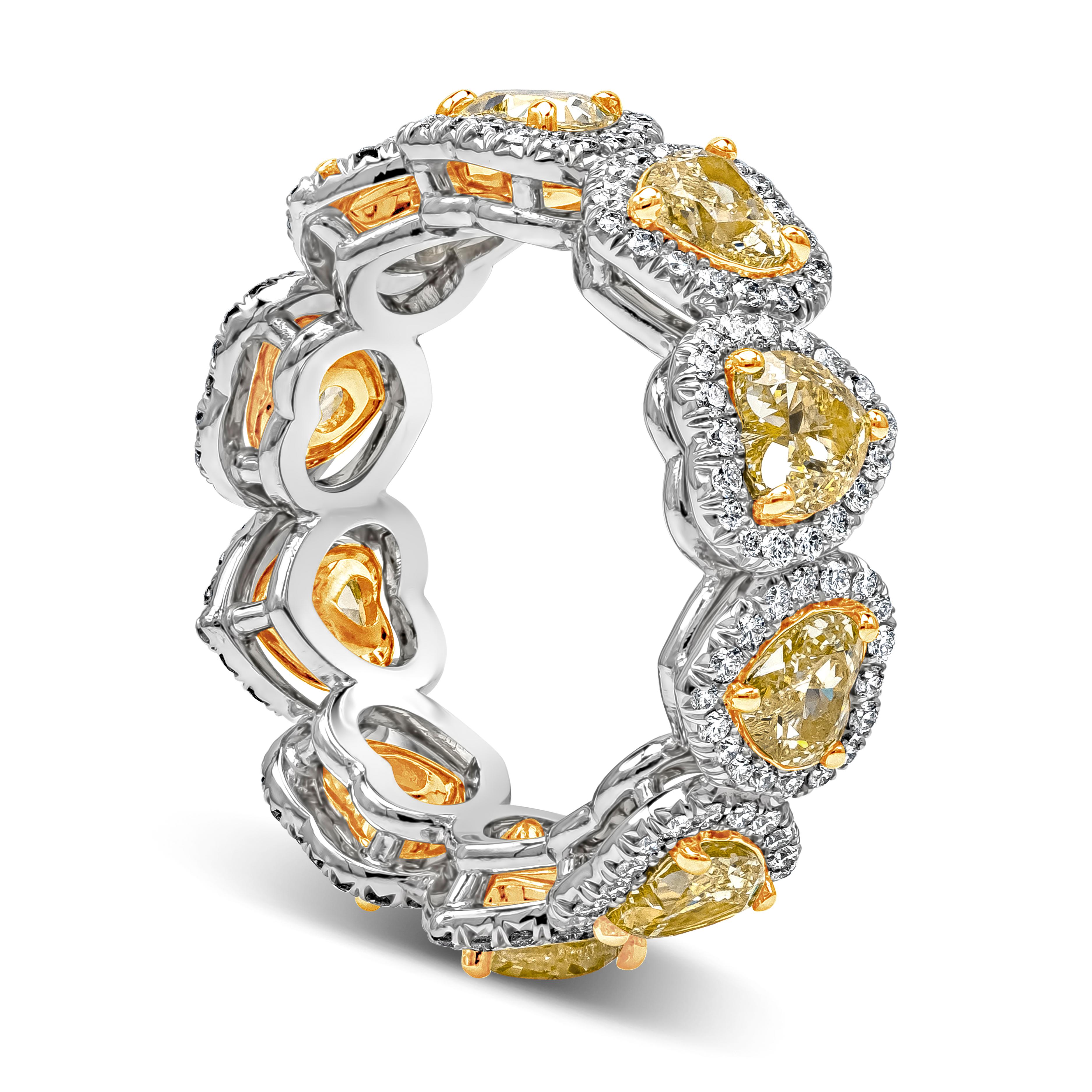 A stylish wedding band style showcasing vibrant heart shape fancy yellow diamonds weighing 3.64 carats total, VS in Clarity, Mounted in 18K Yellow Gold three-prong setting. Each surrounded by a single row of round brilliant diamonds weighing 0.74