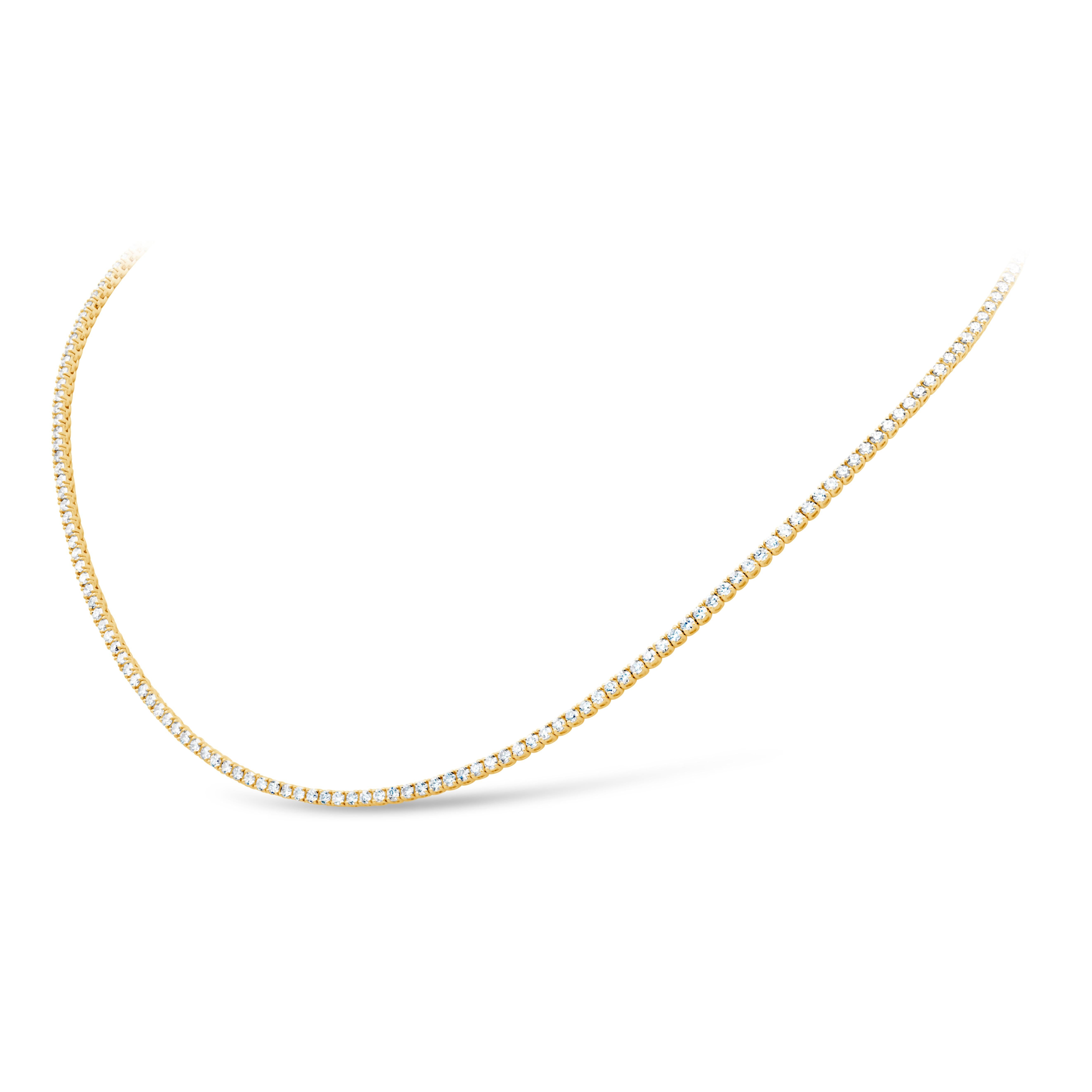 This fine dazzling tennis necklace features a row of brilliant round shape diamonds weighing 3.86 carats total, G-H Color and VS-SI1 in Clarity. Set in a classic four-prong setting and finely crafted in 18K yellow gold. 16 inches in length.

Style