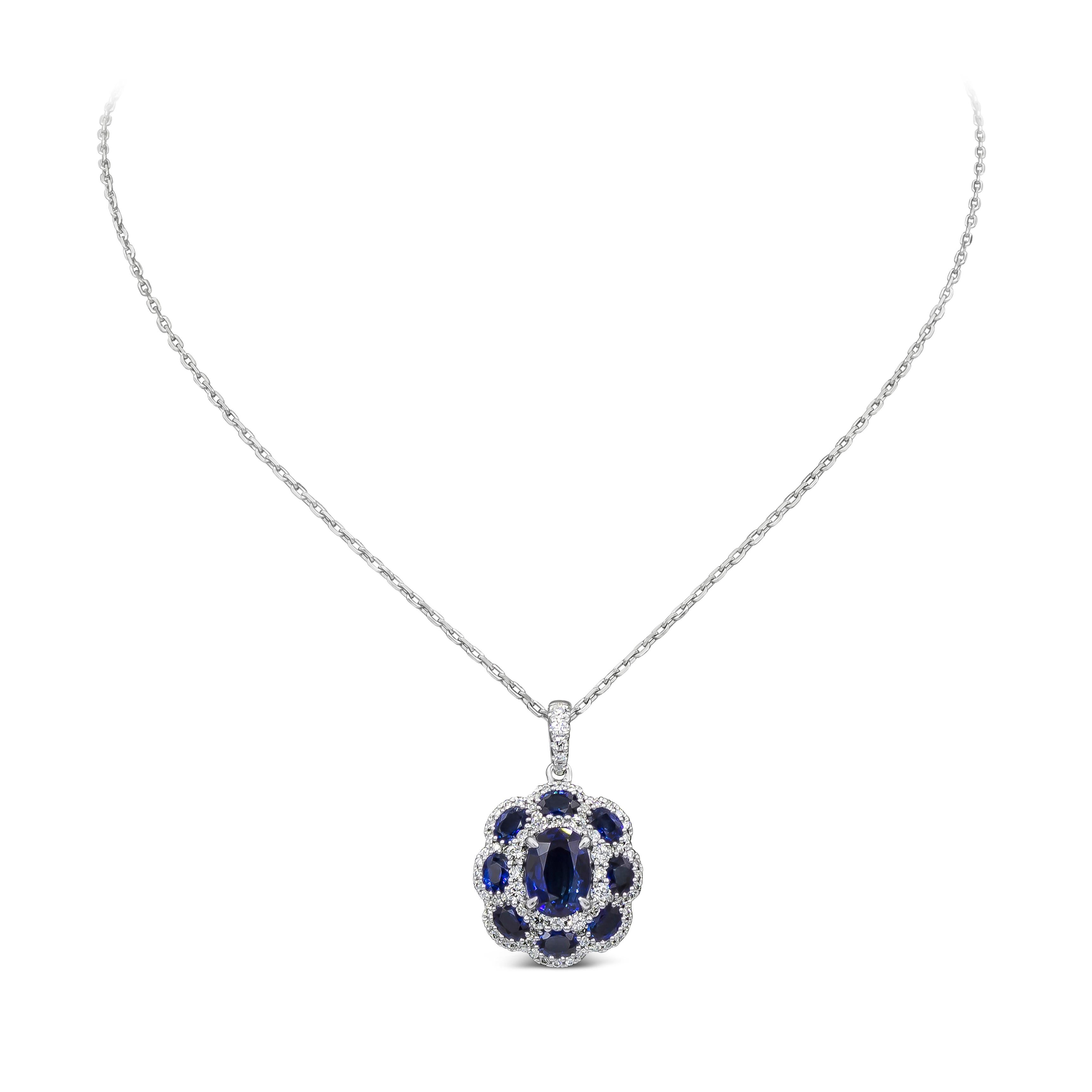 A fashionable piece of jewelry showcasing a 2.12 carats oval cut blue sapphire center stone, surrounded by smaller blue sapphires 1.76 carats in a floral motif style. Finished with brilliant diamond accents weighing 0.68 carats total. Suspended on a