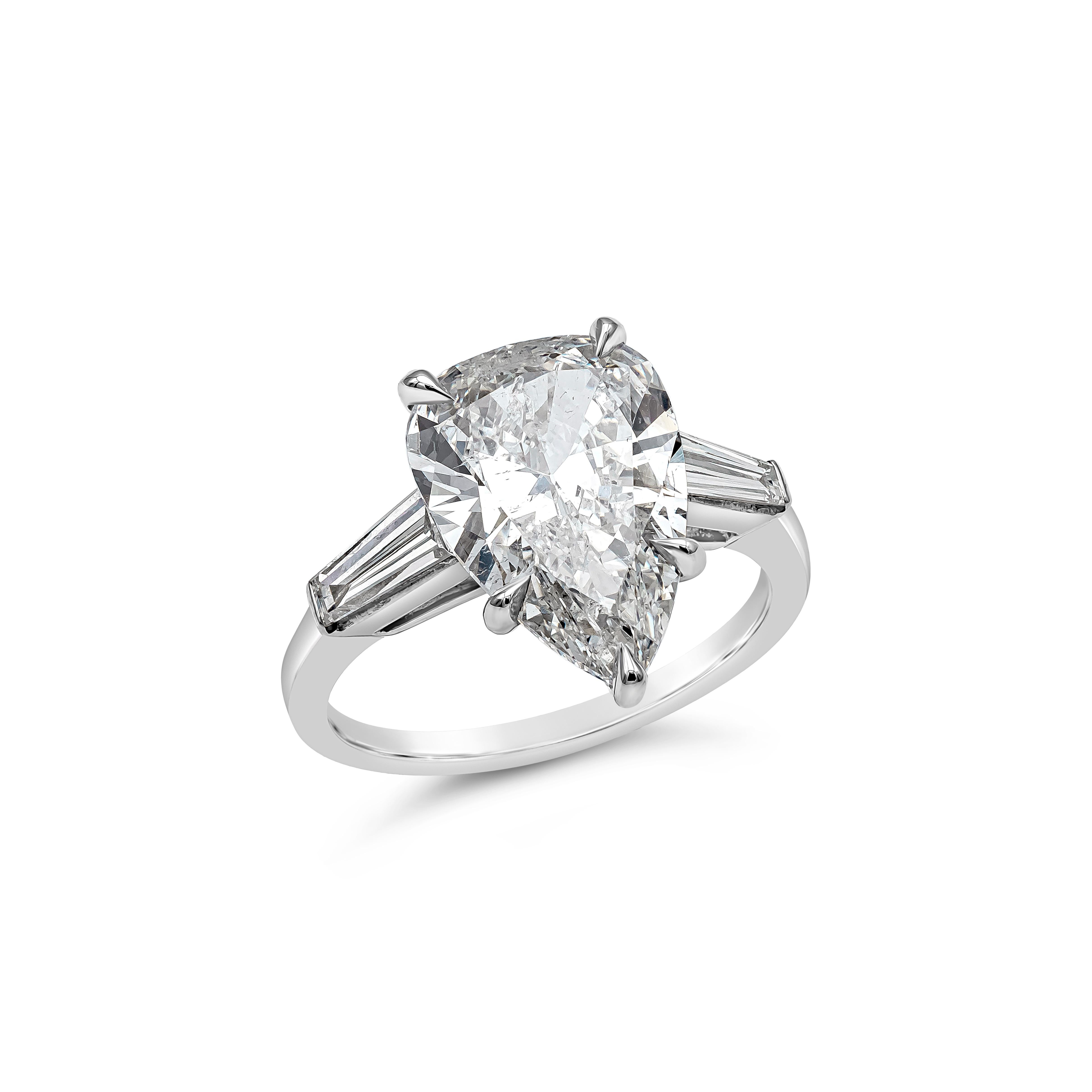  A classic three-stone engagement ring showcasing a 4.04 carat pear shape diamond certified by GIA as I color, SI2 clarity, flanked by baguette shape diamonds on either side. Accent diamonds weigh 0.60 carats and are approximately H color, VS
