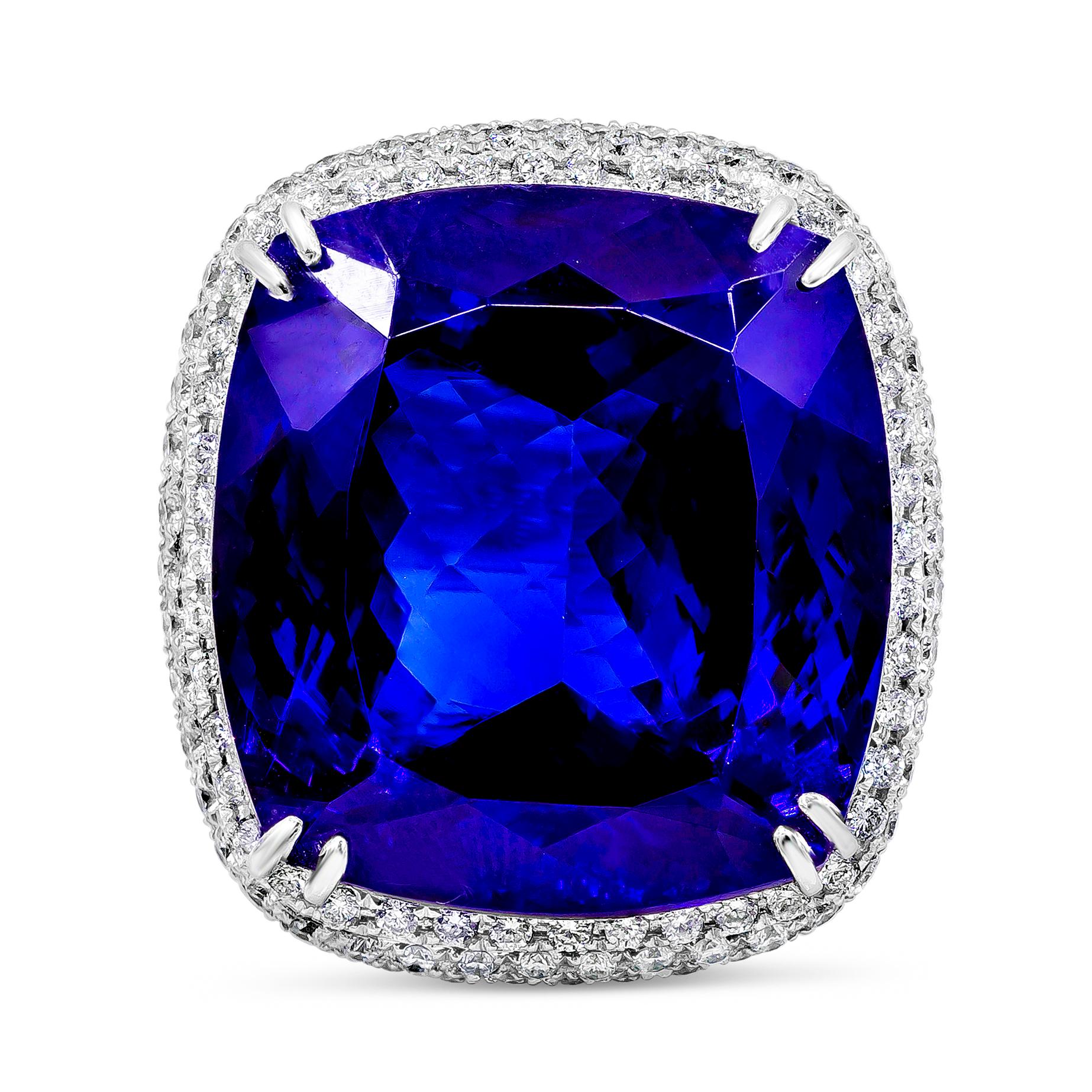 A splendid cocktail ring showcasing an amazing color-rich cushion cut tanzanite weighing 44.04 carats total. Elegantly set in a double claw prongs setting, with micro-pave diamonds set around the center stone. Diamonds weigh 2.43 carats total. Made
