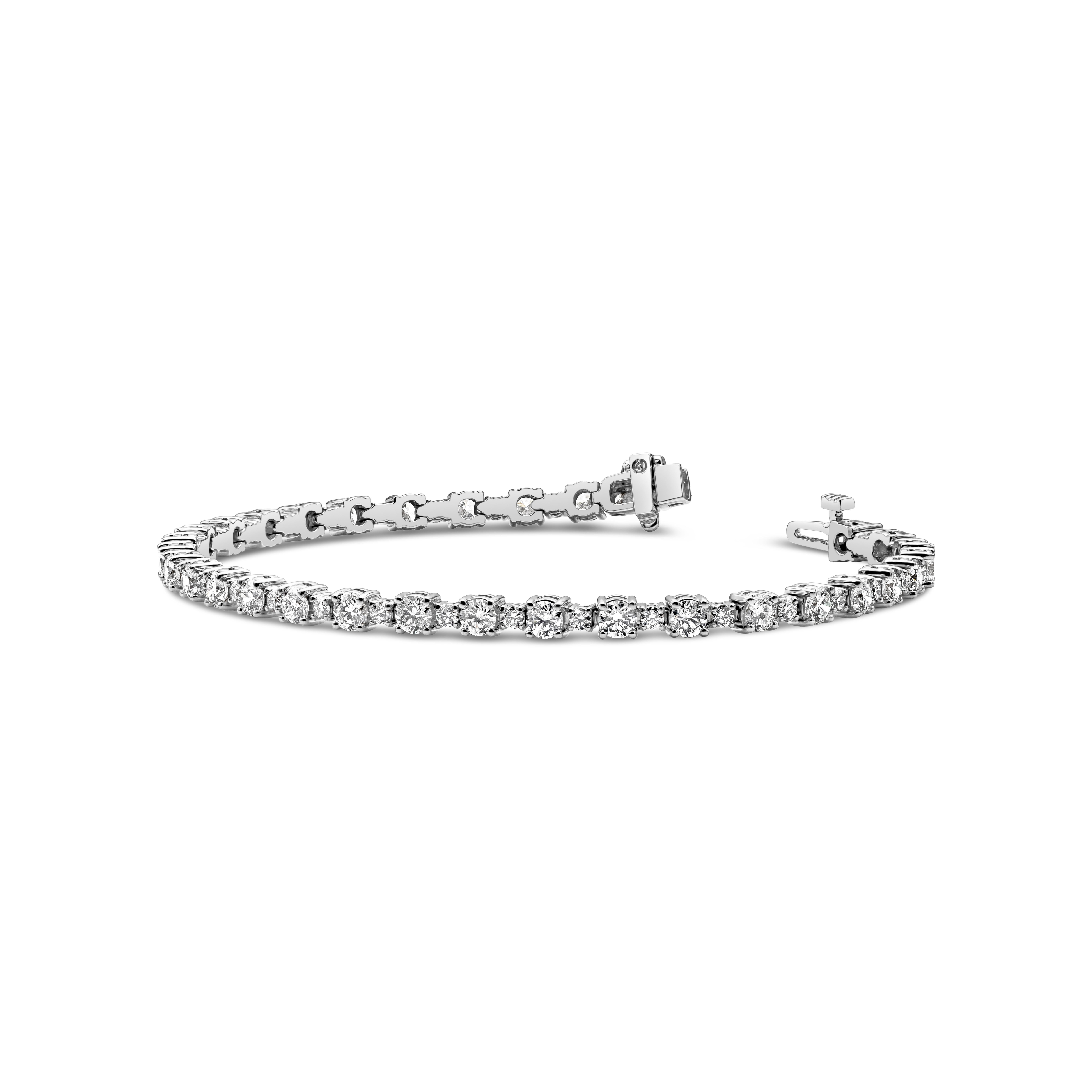 Un bracelet de tennis classique, mettant en valeur une rangée alternée de petits et grands diamants ronds de taille brillant pesant au total 4,53 carats de couleur G et de pureté VS2. Ce bracelet est doté d'un mécanisme de double verrouillage pour