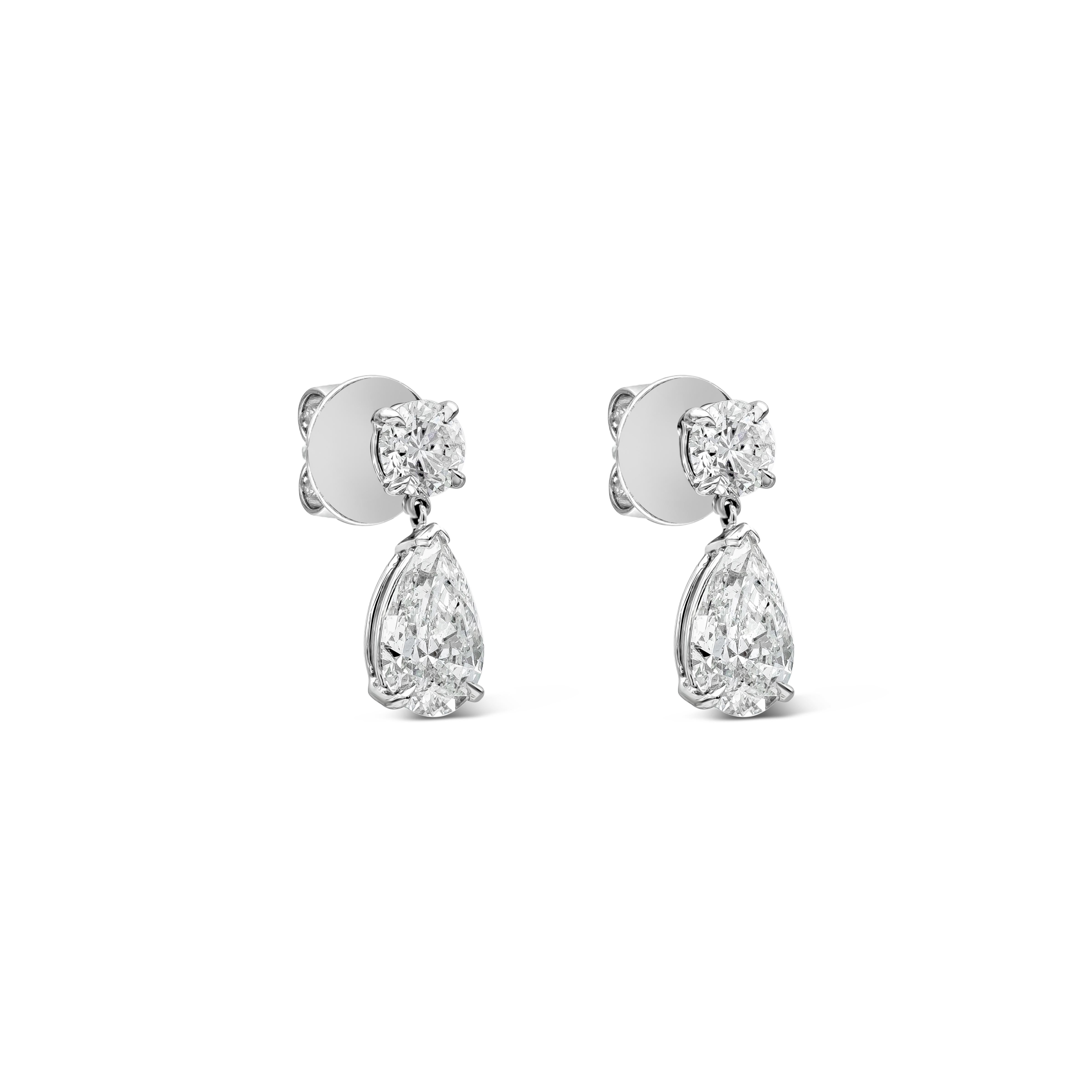 A classy pair of dangle earrings featuring a pear shape diamond drop suspended on a round brilliant diamond. Pear shape diamonds weigh 3.28 carats total, E-F Color and I1 in Clarity. Round diamonds weigh 1.25 carats total, F Color and SI2 in