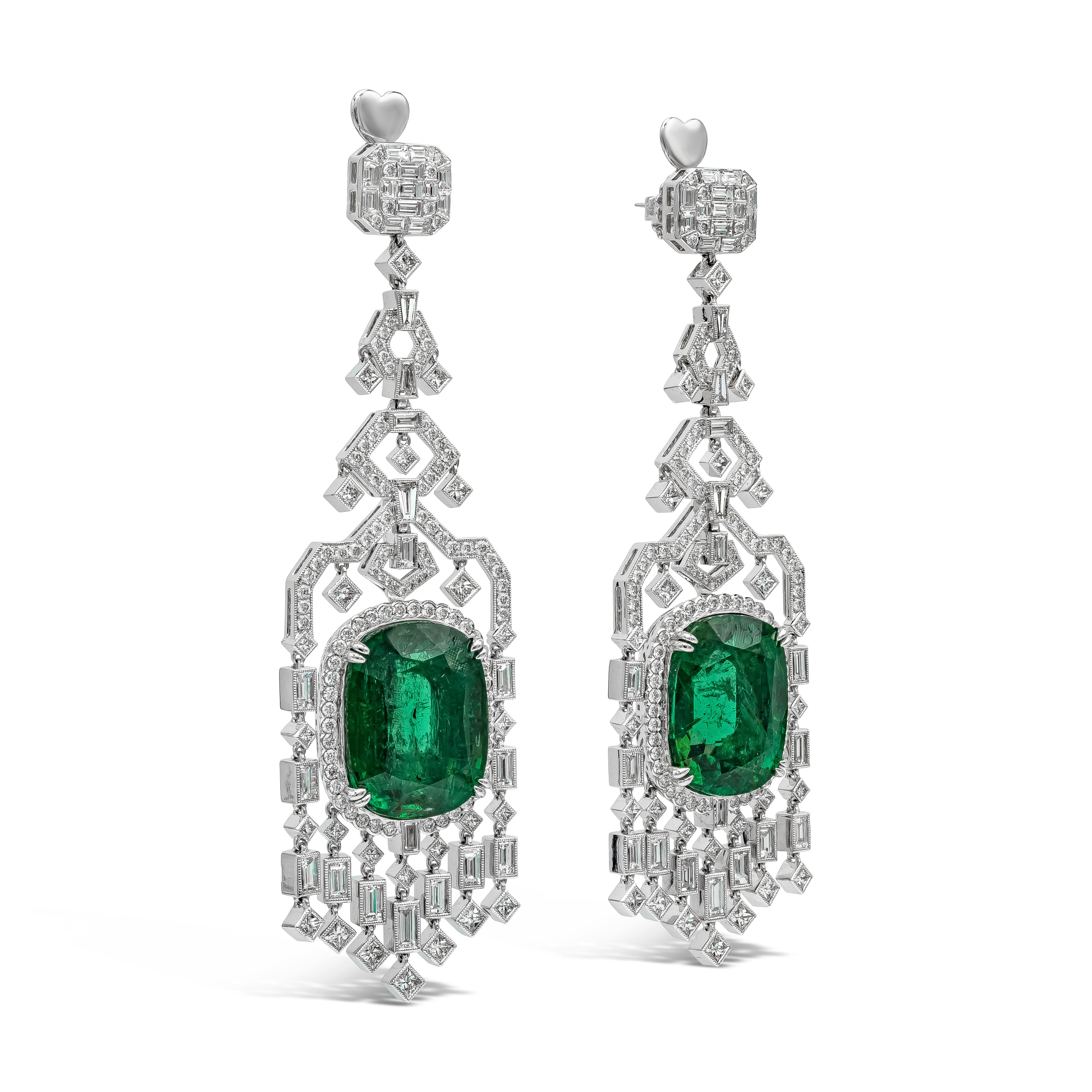 An elegant and rare pair of high end earrings showcasing two large green emeralds weighing 45.76 carats total, set in an intricately-designed chandelier design accented with mixed cut  brilliant diamonds. Diamonds weigh 9.25 carats total. Made in