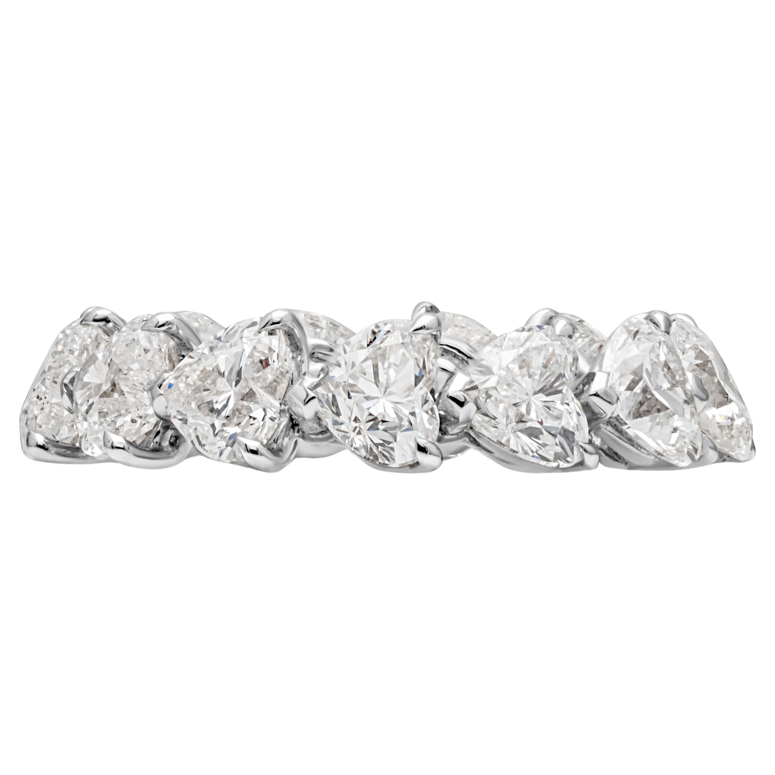 Showcasing a classic and unique wedding band set in a timeless flexible three prong basket setting with 13 heart shape diamonds weighing 5.36 carats total, H-S color and F in clarity. Finely made in 18k white gold and Size 5.75 US resizable upon