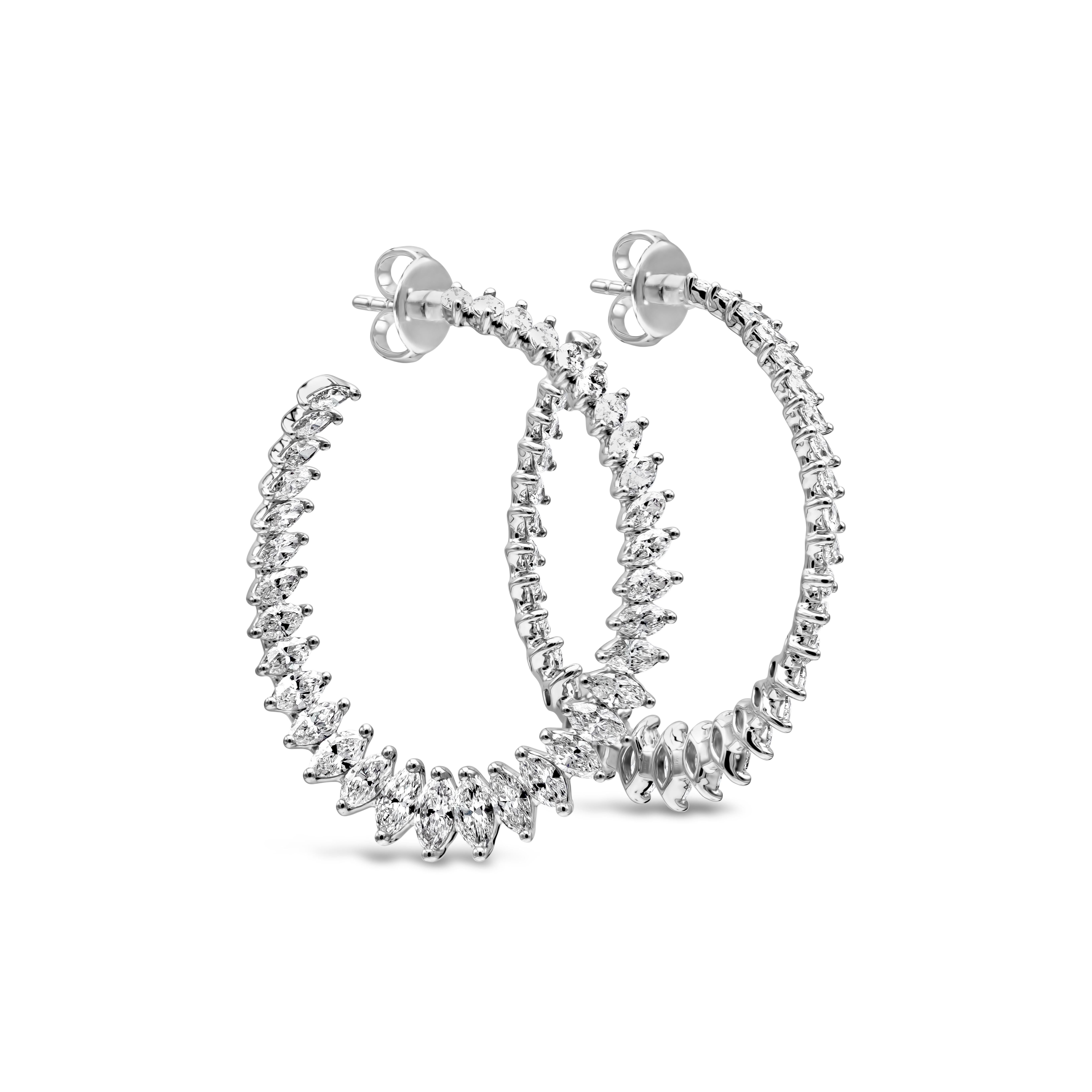 A unique and fashionable pair of hoop earrings showcasing a row of marquise cut diamonds forming a circular design. Marquise cut diamonds weigh 5.71 carats total. The length of this beautiful pair is 37mm while the width is 30mm. The weight is 10.21