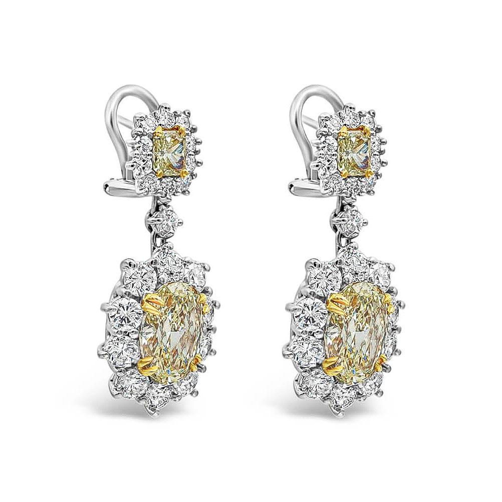 Showcasing a gorgeous pair of two fancy yellow oval cut diamonds weighing 6.15 carats total surrounded by sparkling round diamonds in a creative floral motif. Suspended on vibrant radiant cut yellow diamonds weighing 1.02 carats. Accent round