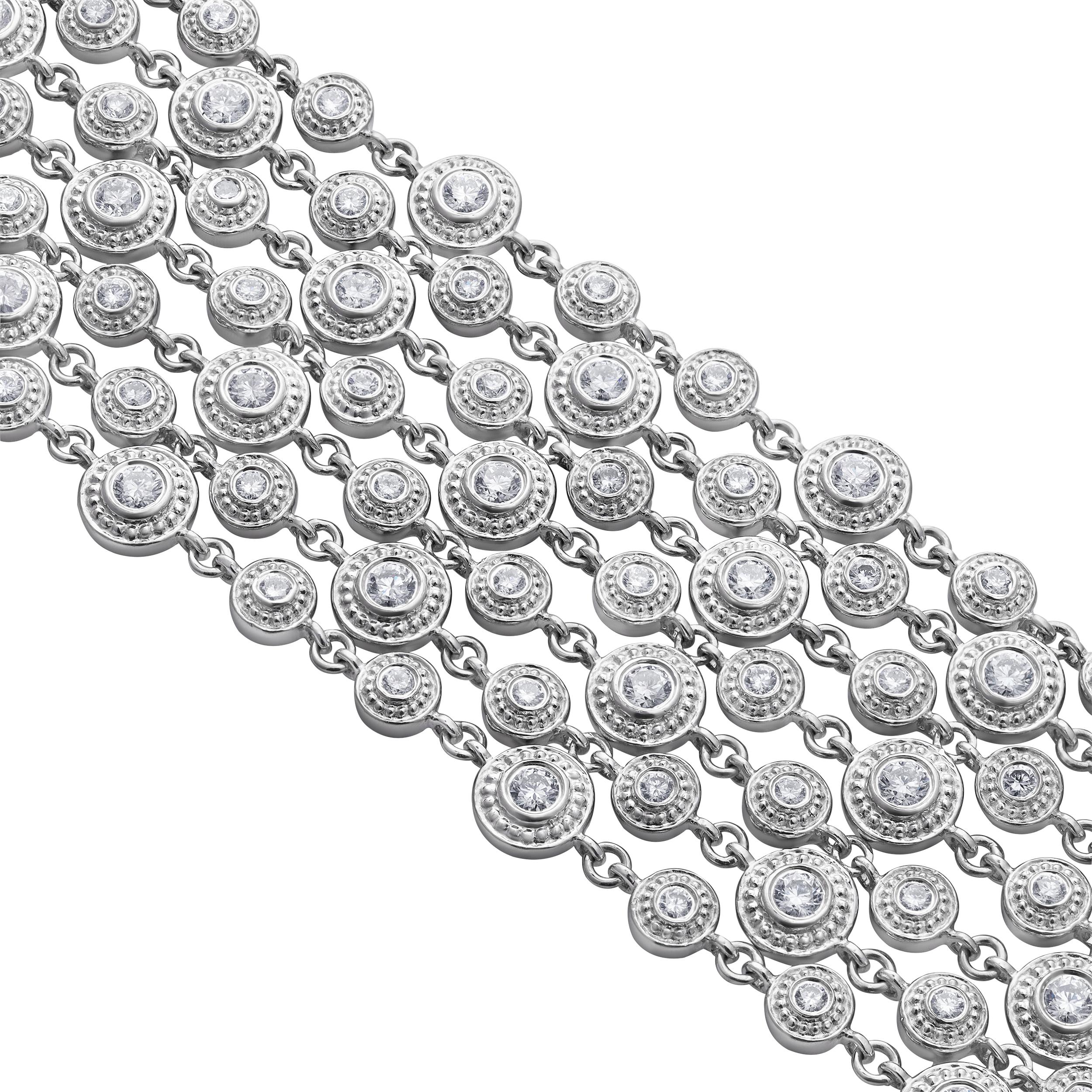 Preciosa pulsera de moda, con diamantes redondos de talla brillante que pesan 6,58 quilates en total con color G y claridad VS, engastados en bisel con un halo de cuentas. Finamente fabricada con oro blanco de 18 quilates, mide 7,25 pulgadas de