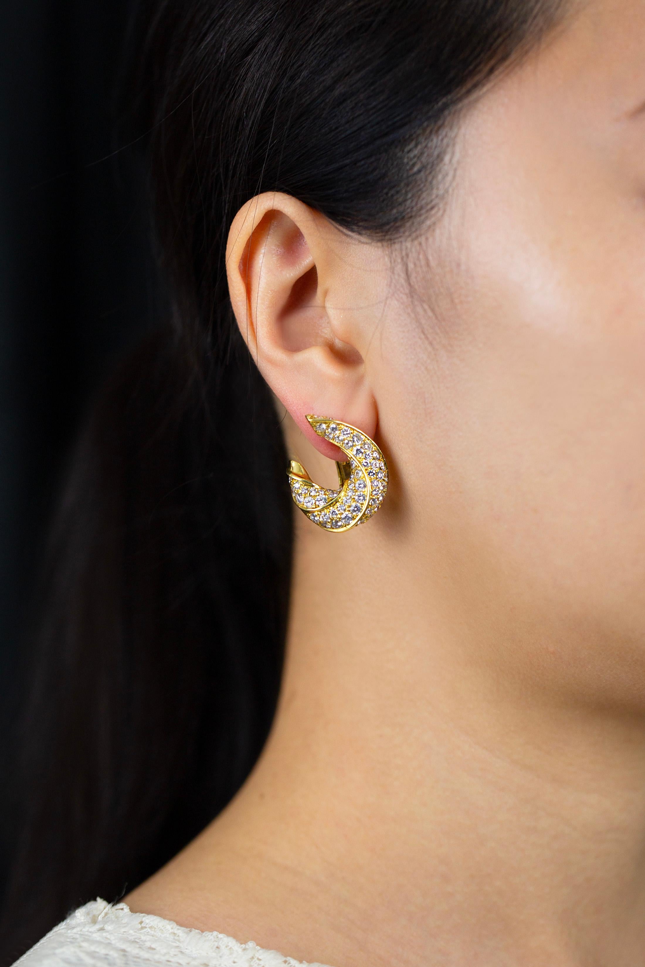 Une paire de boucles d'oreilles à la mode, mettant en valeur des diamants ronds de taille brillant pesant 7,03 carats au total, sertis dans un motif torsadé complexe. Finement réalisé en or jaune 18 carats. Livré avec des clips oméga et des