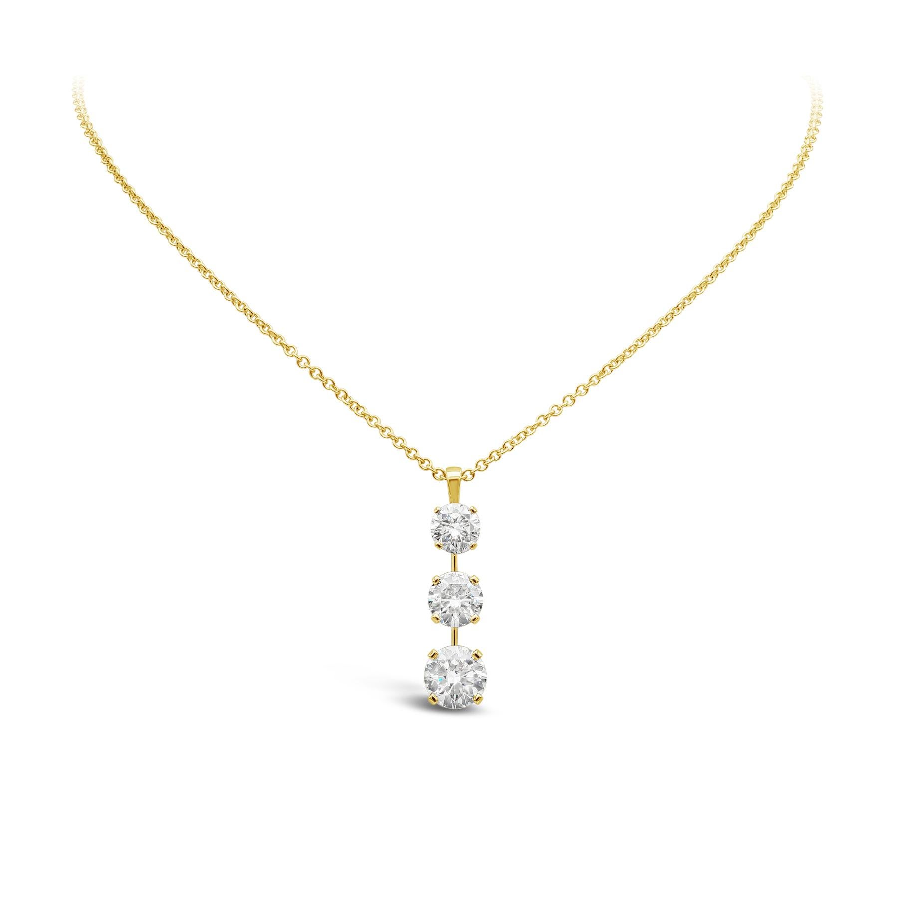 A beautiful drop necklace style, showcasing three round brilliant cut diamonds graduating in size, set in a polished 18K yellow gold mounting. The first diamond weighs 1.74 carats and certified by GIA as O-P color and SI2 clarity. The second and