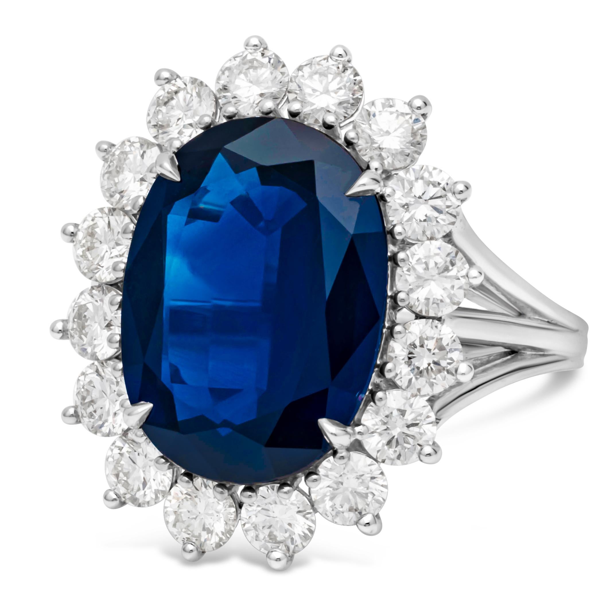A color-rich piece of jewelry showcasing an oval cut blue sapphire center stone weighing 7.71 carats, set in a classic four prong basket setting. Surrounded by single row of brilliant round diamonds weighing 1.85 carats total, set in a three-prong