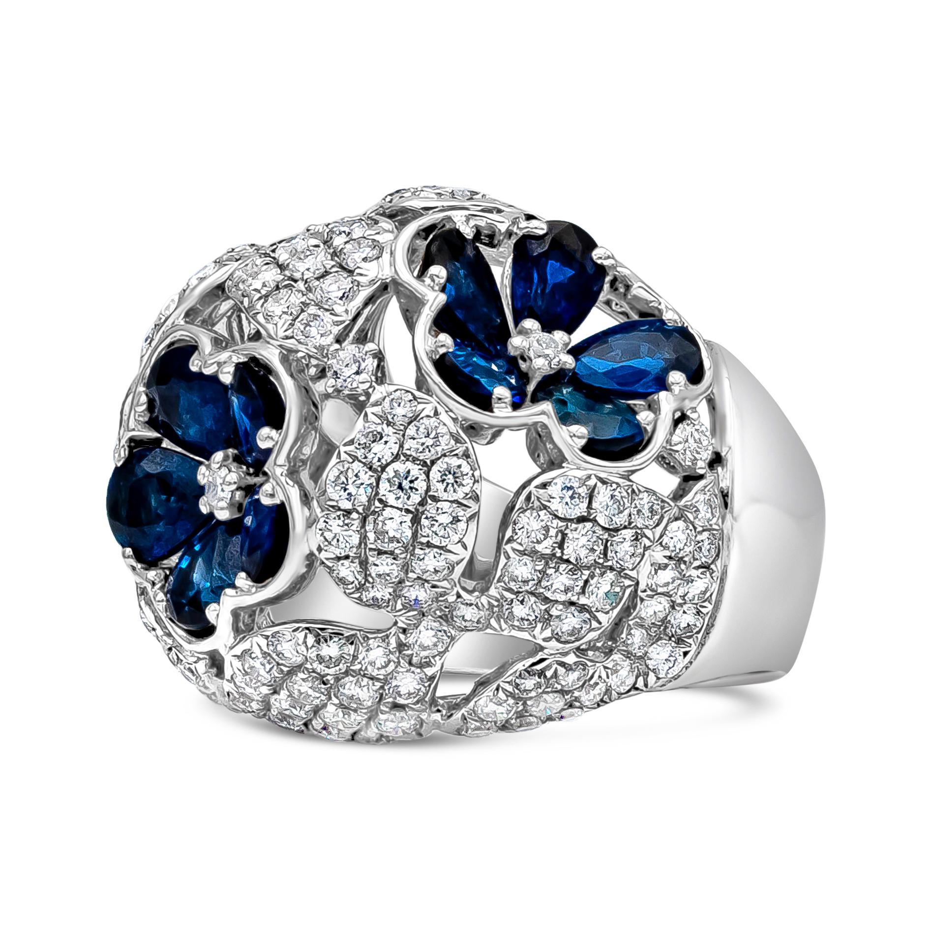 A beautiful and fashionable dome ring showcasing a cluster of blue sapphires set in a flower-motif design, accented by round brilliant diamonds micro-pave set in a four leaf clover design. Blue sapphires weigh 5.02 carats total, diamonds weigh 3.09
