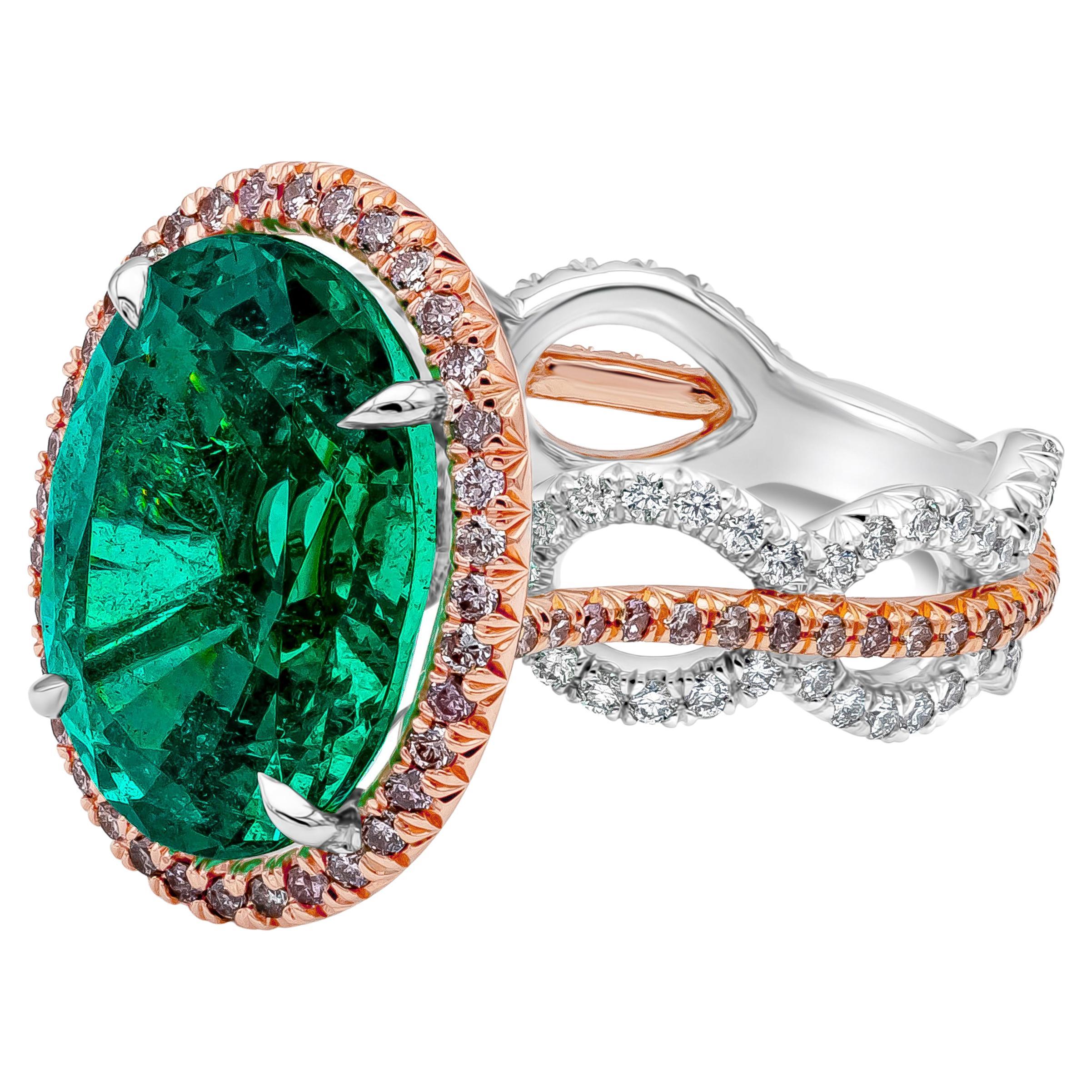 A color rich and vibrant cocktail ring showcasing a GRS certified 9.61 carat oval cut green emerald gemstone surrounded by a row of round brilliant pink diamonds. Set in an open work circular design 18K Rose Gold and Platinum shank accented by round