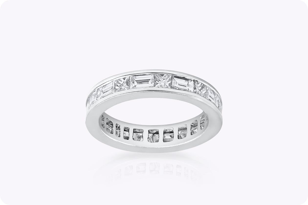 A chic and sophisticated eternity wedding band design showcasing baguette and princess cut diamonds channel set in a polished platinum composition. Baguette diamonds weigh 1.22 carats total while the princess cut diamonds weigh 0.94 carats total.