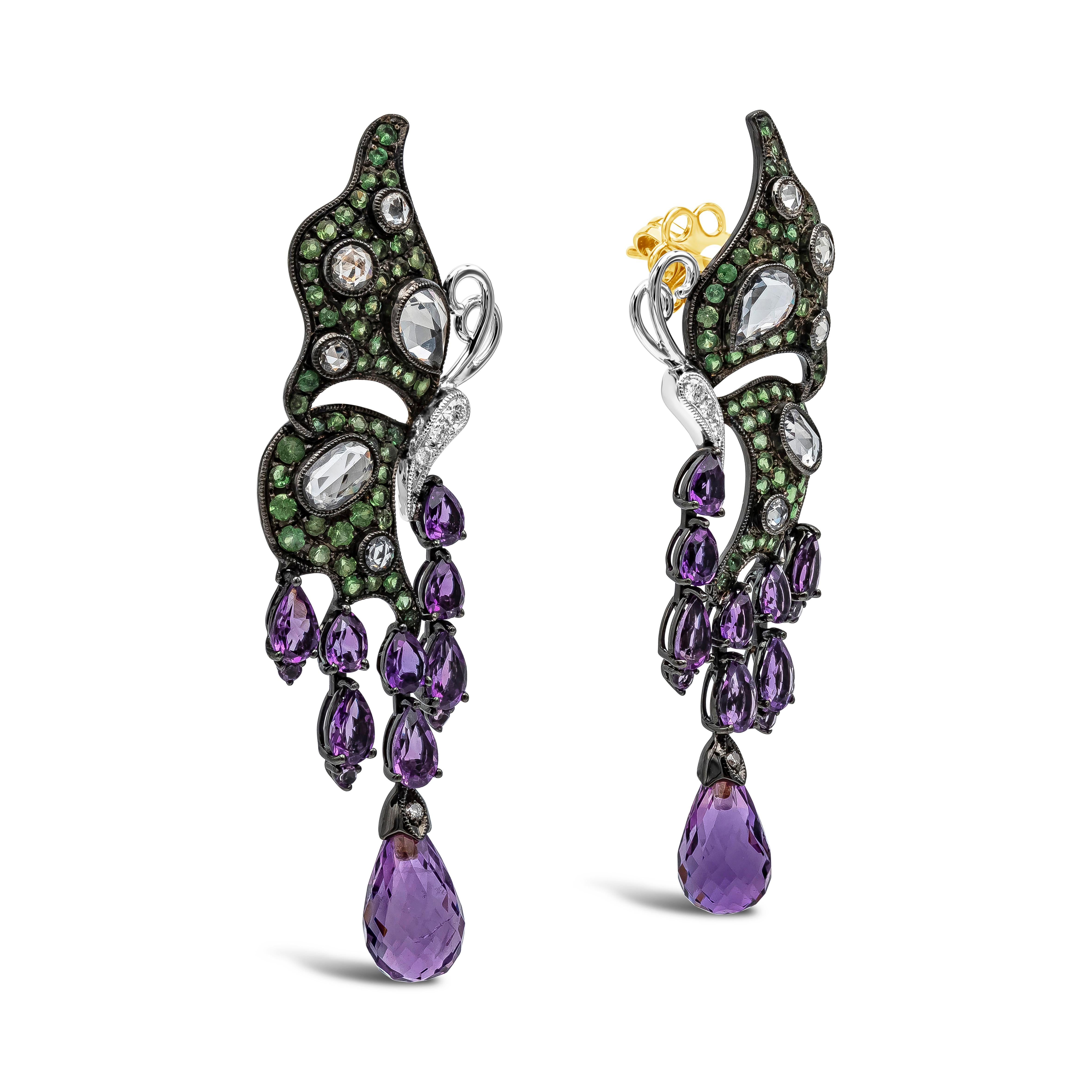 A beautiful and intricately-designed pair of dangle earrings showcasing an 18k gold butterfly design, set with color-rich tsavorites weighing 1.50 carats total and rose cut diamonds/sapphires . Hanging from the butterfly are pear and briolette shape