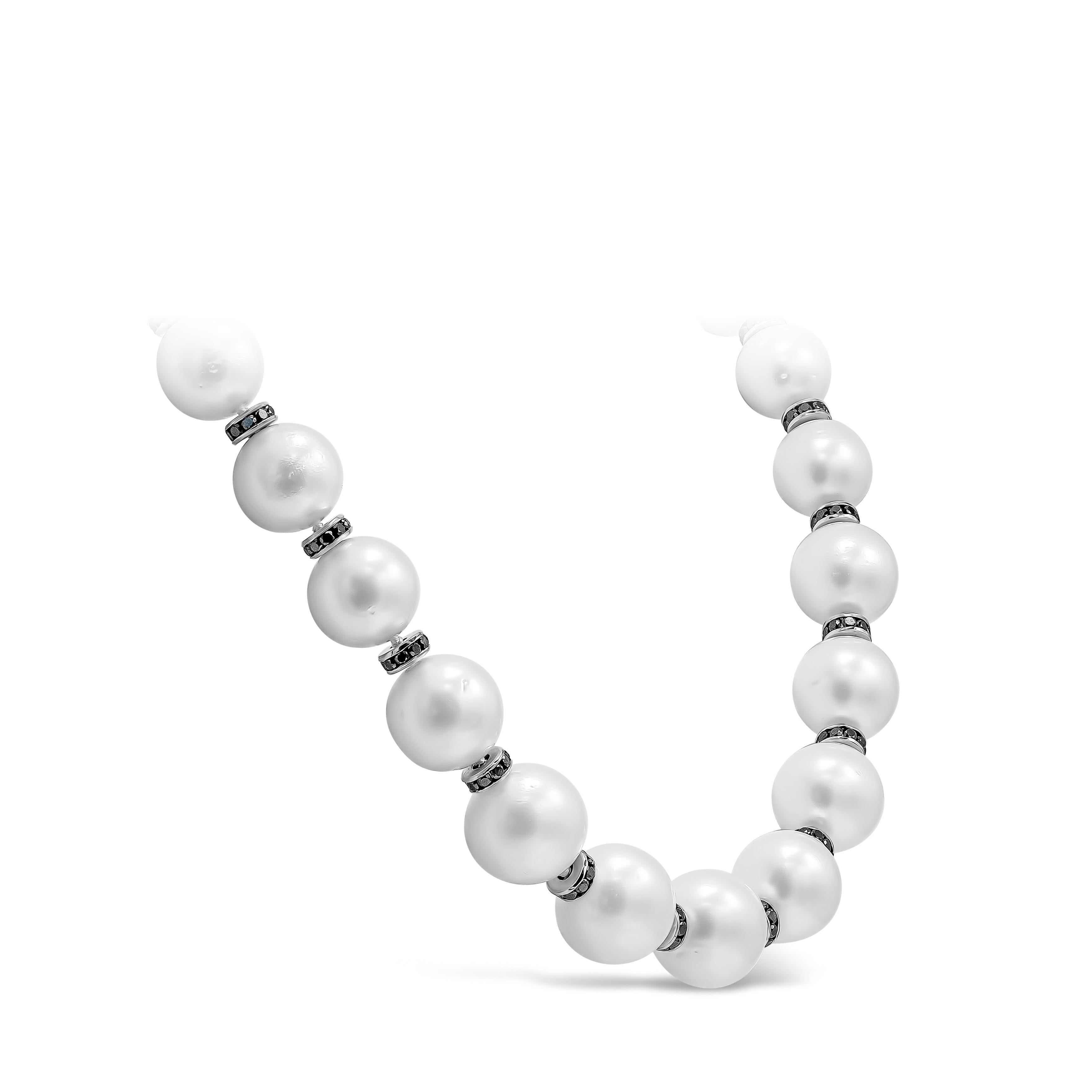A beautiful and brilliant necklace showcasing a row of 28 graduating natural white pearls, spaced by 14K white gold rondelles set with round black diamonds. 256 pieces of black diamonds weigh 11.02 carats total. Pearls are approximately 13mm-16.30mm