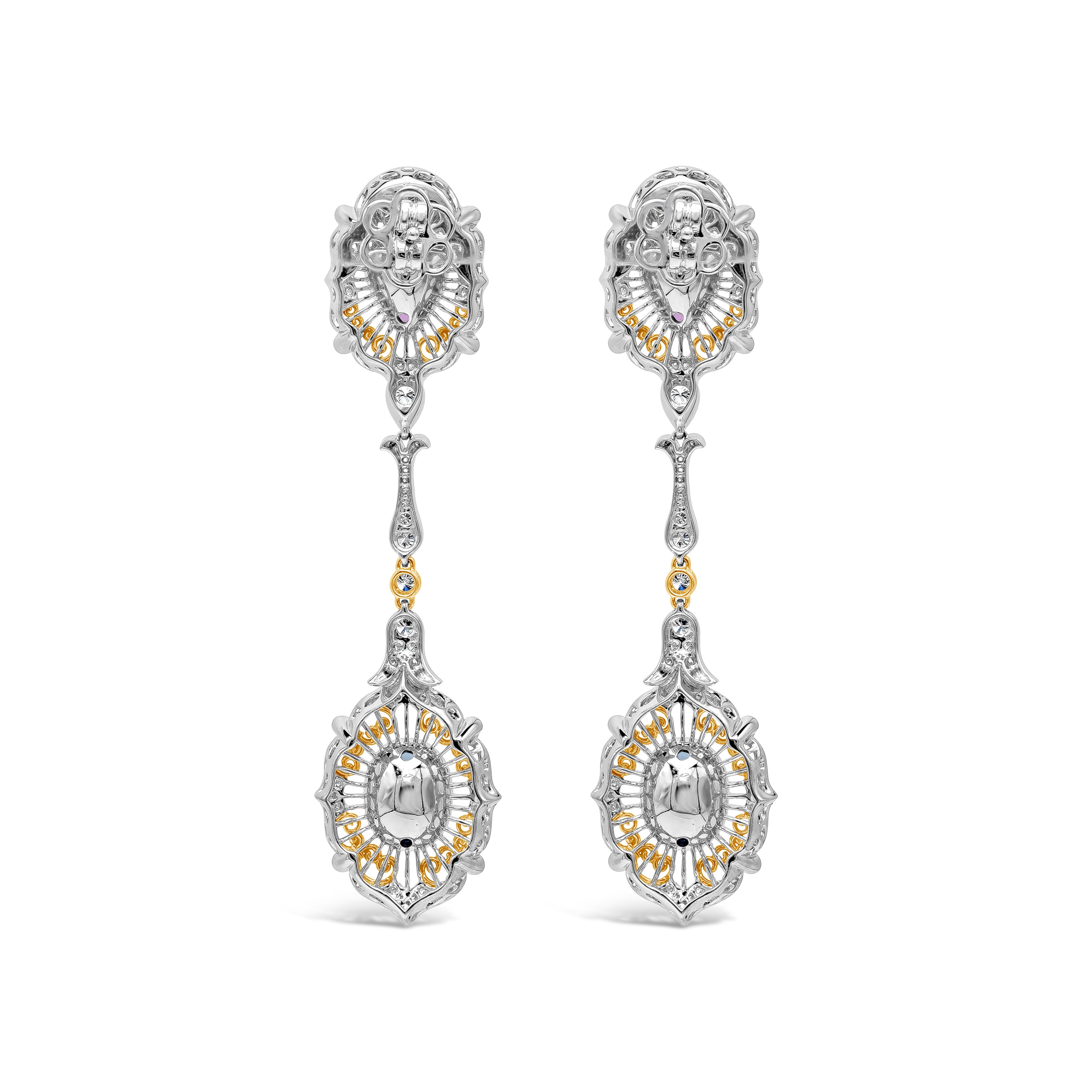 A beautiful and unique pair of dangle earrings. Each earring showcases a pink and blue oval cut sapphires, set in an intricately-designed mounting accented with diamonds. Pink sapphires weigh 2.86 carats; blue sapphires weigh 2.87 carats total;
