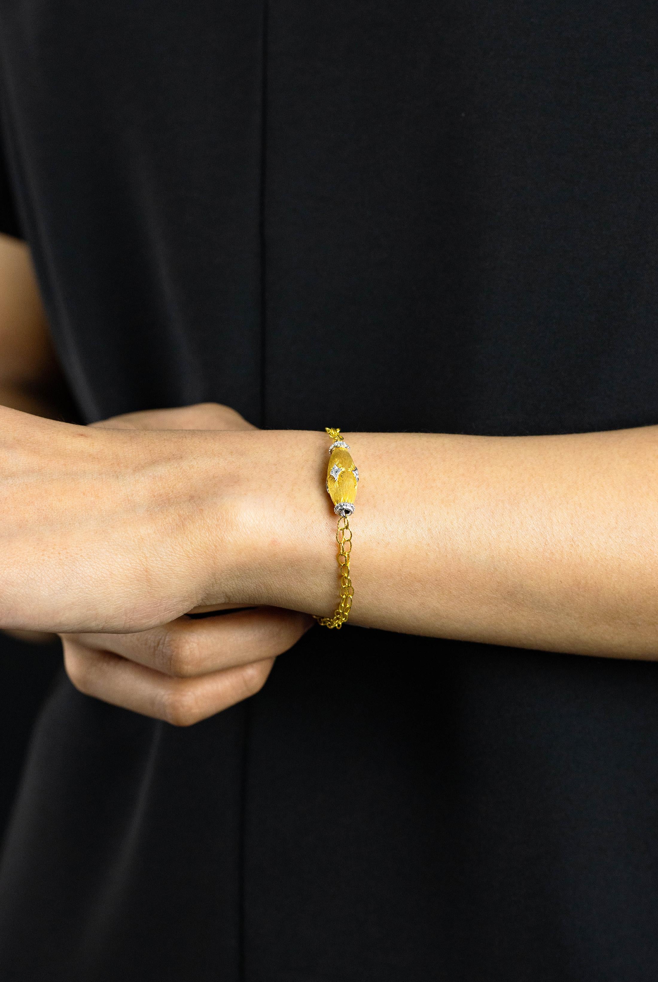 Ein einfaches und einzigartiges Armband mit einer eiförmigen Figur, die mit runden Brillanten besetzt ist. Das Armband hat eine gebürstete Oberfläche. Die Diamanten wiegen insgesamt 0,10 Karat. Fein gearbeitet in 18 Karat Weiß- und Gelbgold.