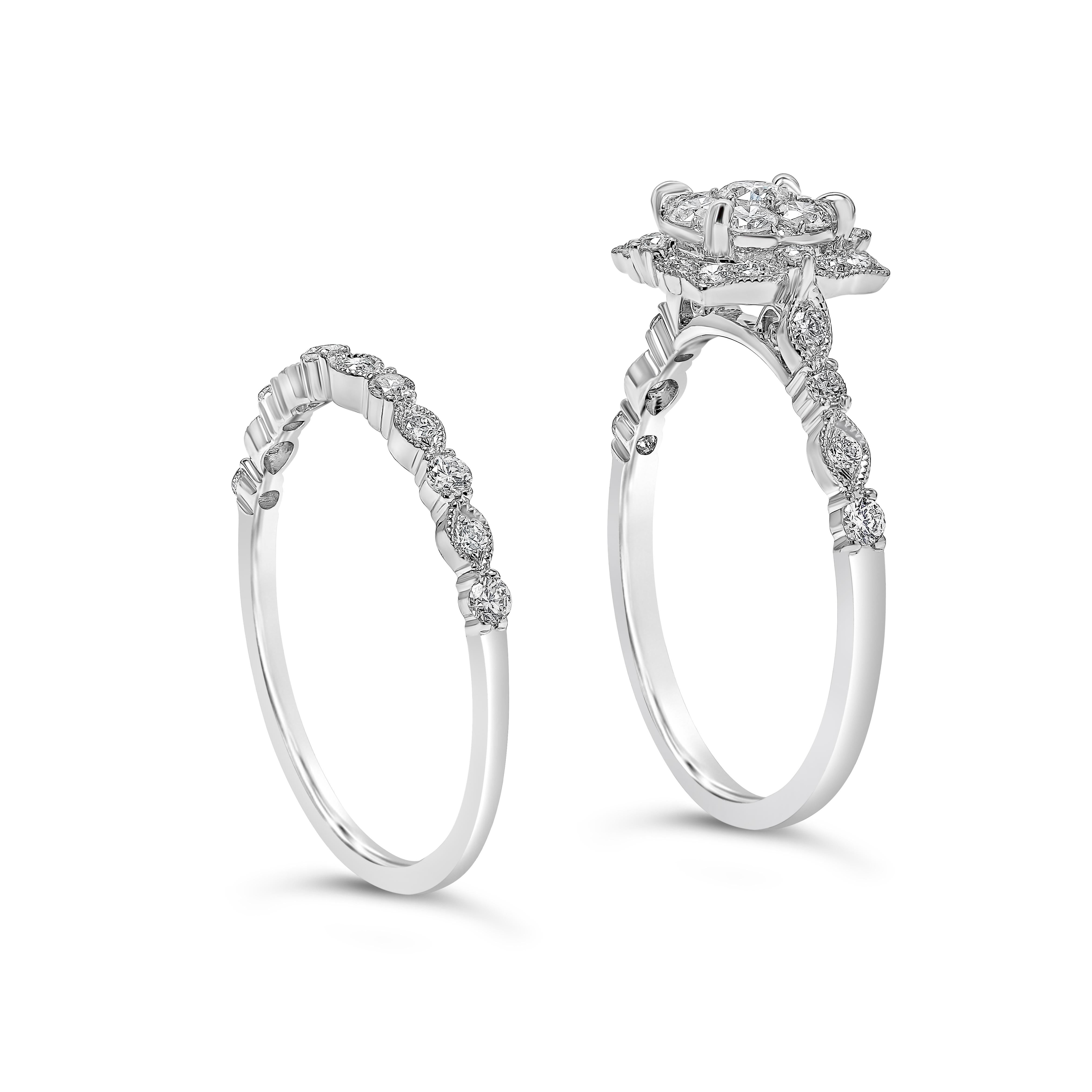 A unique engagement ring and wedding band set. The engagement ring features a cluster of round cut diamonds, surrounded by a halo in an intricate design. Accompanied with a matching wedding band. Both rings have a diamond encrusted shank in a