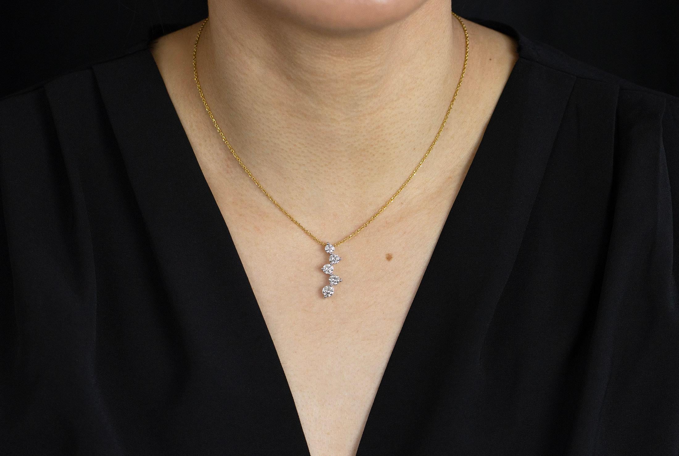 A simple pendant necklace showcasing five graduating round diamonds, set in a constellation style drop in 14k white gold. Diamonds weigh 1.54 carats total. Suspended on a 16 inches adjustable yellow gold chain.

Style available in different price