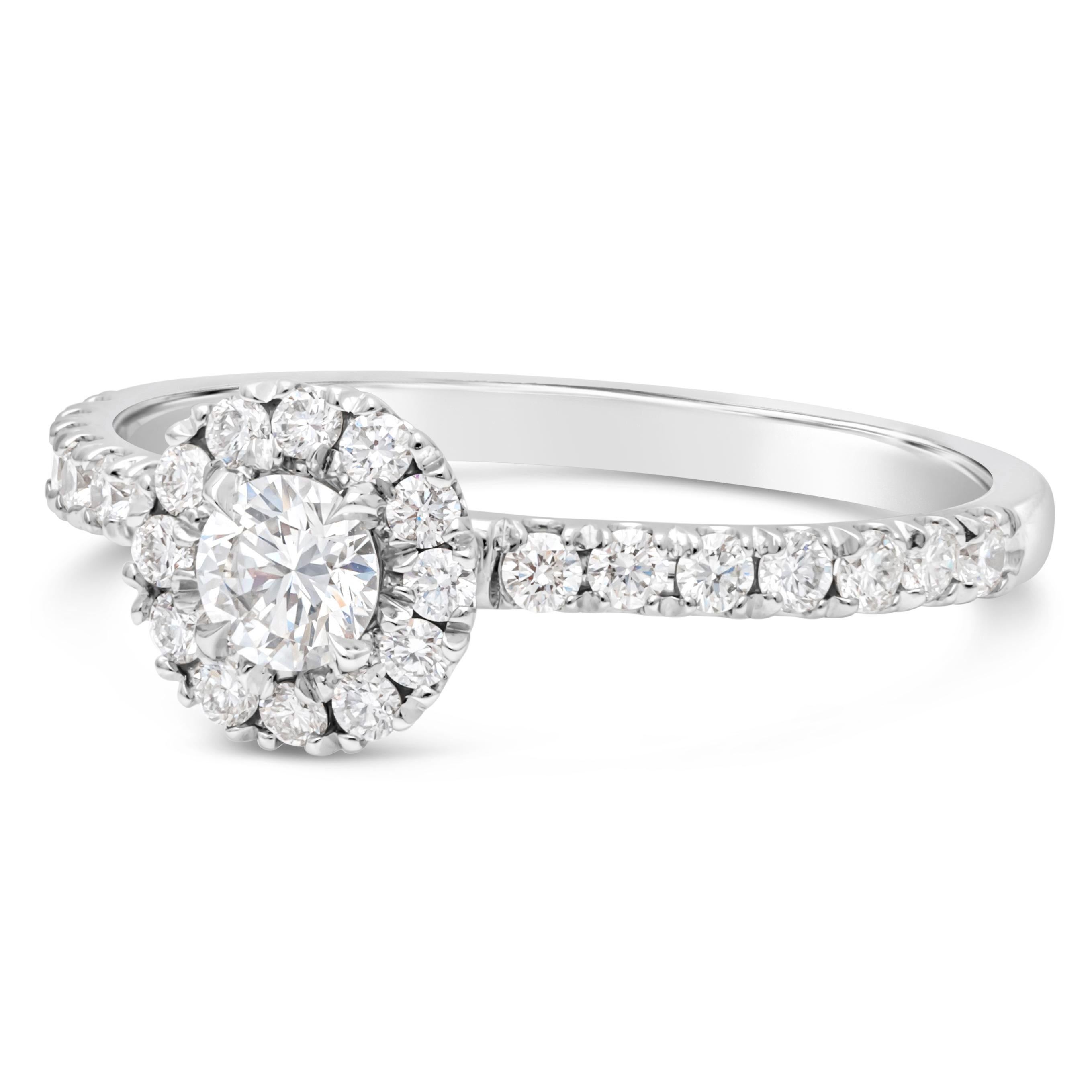 A classic engagement ring, showcasing a GIA certified 0.21 carat round brilliant cut diamond certified by GIA as F color and VS1 clarity. Surrounded by round brilliant cut diamonds in a halo setting and accented by a diamond encrusted shank in a