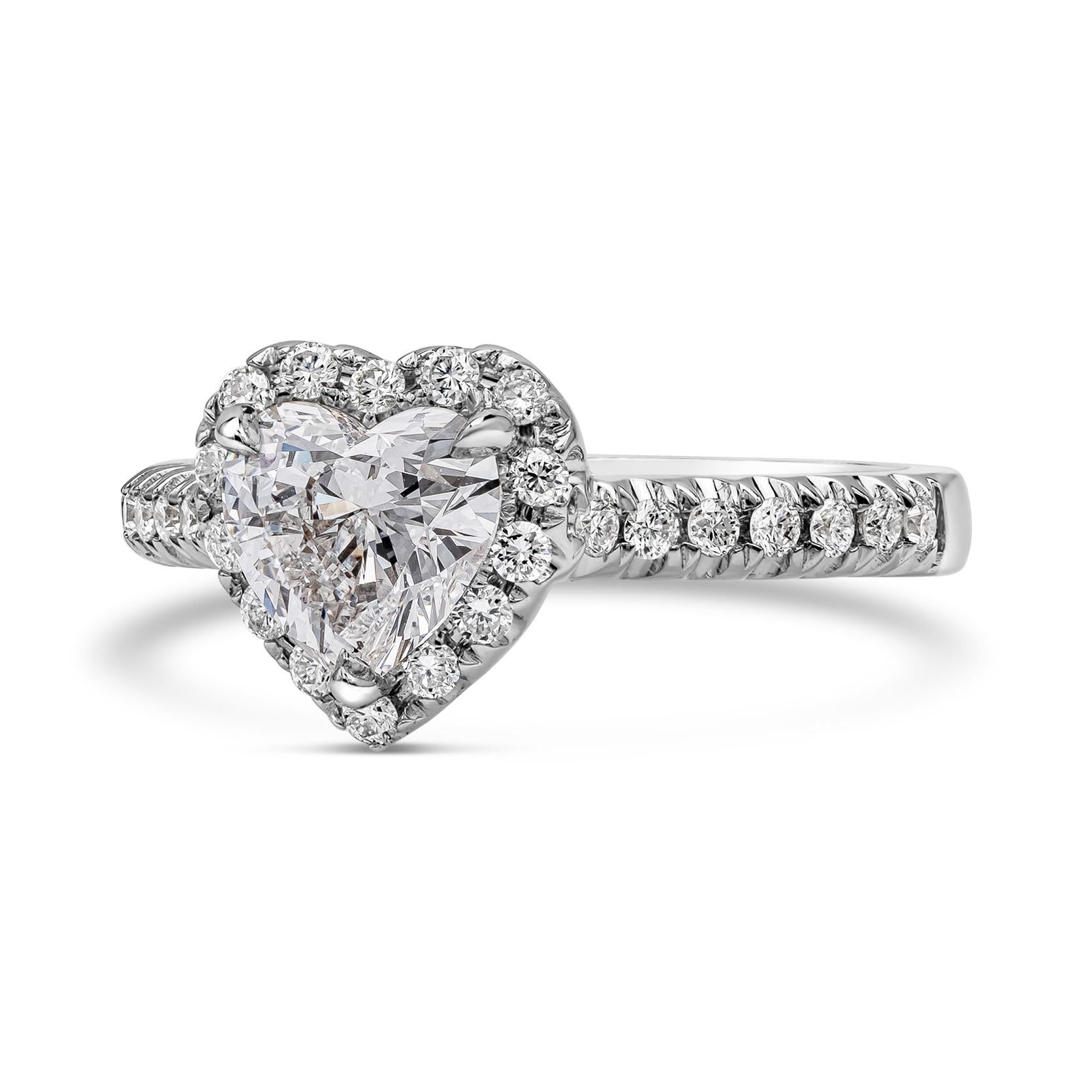 Features a 1.07 carats heart shape diamond certified by GIA as D color and SI1 in clarity. Surrounding the center diamond is a single row of round brilliant diamonds, set in a 18K white gold mounting. Accent diamonds weigh 0.34 carats total. Size