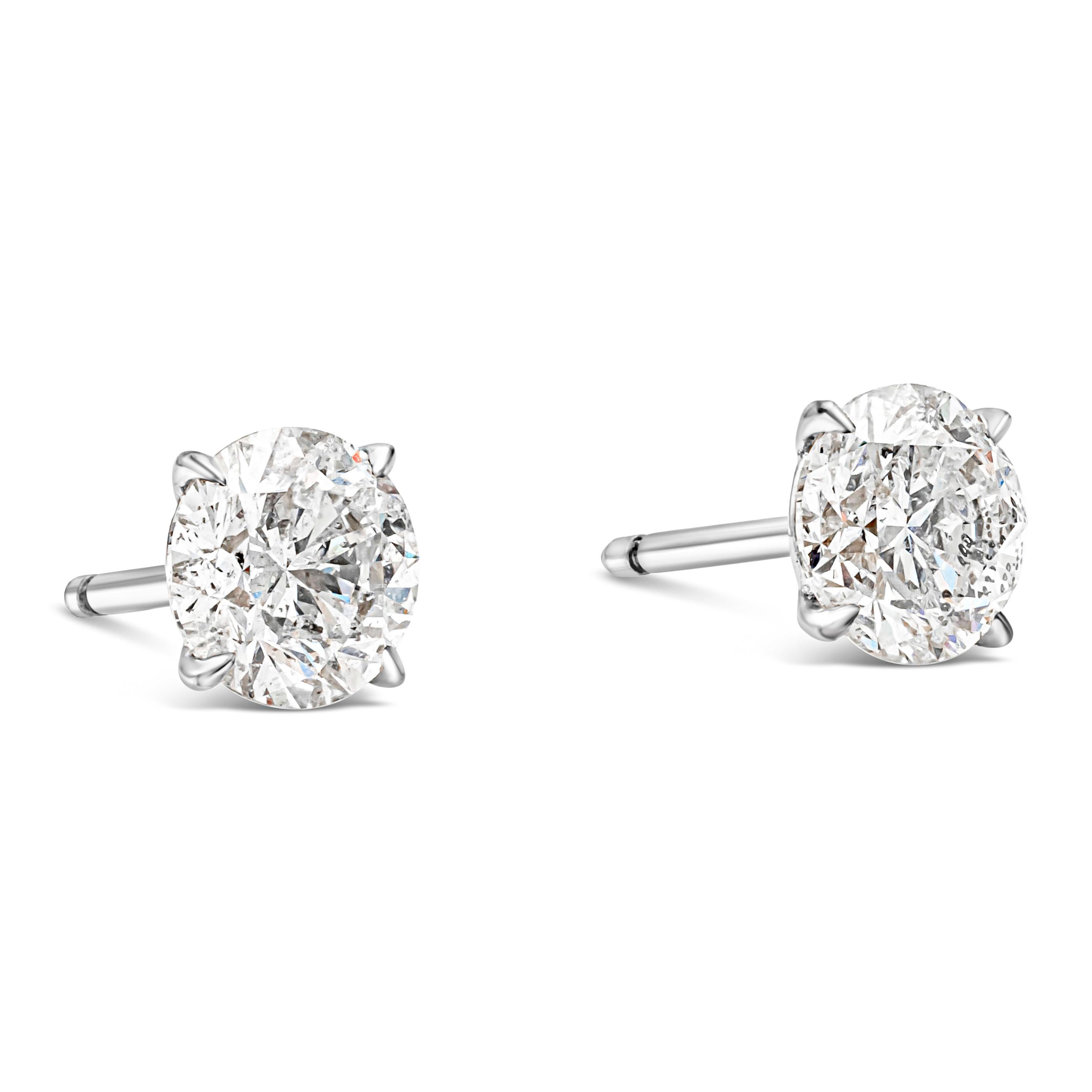 Classic pair of stud earrings showcasing two GIA Certified round brilliant diamonds, each weighing 1.29 carats and 1.21 carats, G-H Color and I2 in Clarity respectively.  Mounted in a timeless four-prong martini setting. Made with 18K White