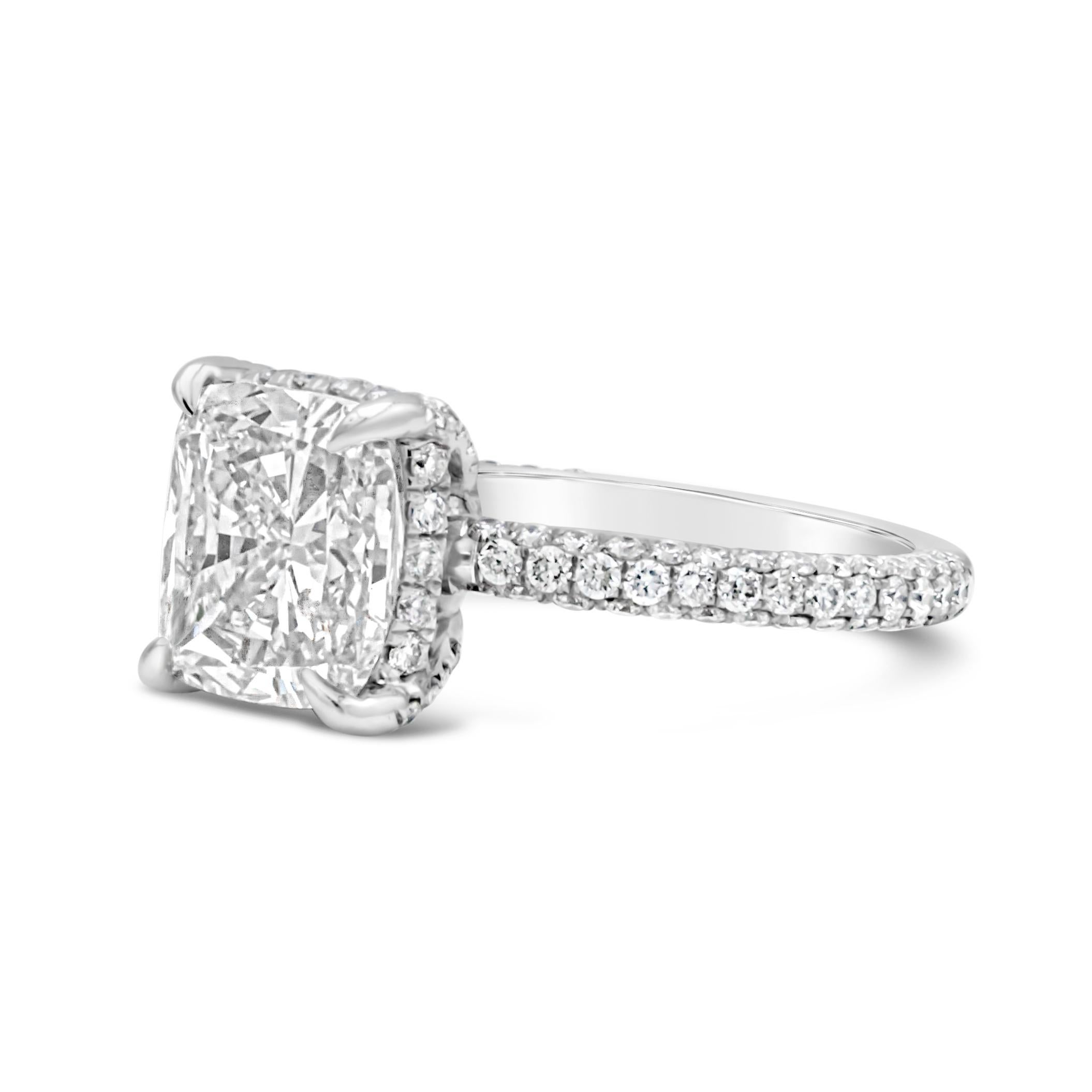 An elegant engagement ring, showcasing a 3.01 carats cushion cut diamond certified by GIA as J color and I1 clarity, set on a four claw prong basket. Accented by 120 round brilliant cut diamonds weighing 0.85 carat total, set on a scalloped pavé