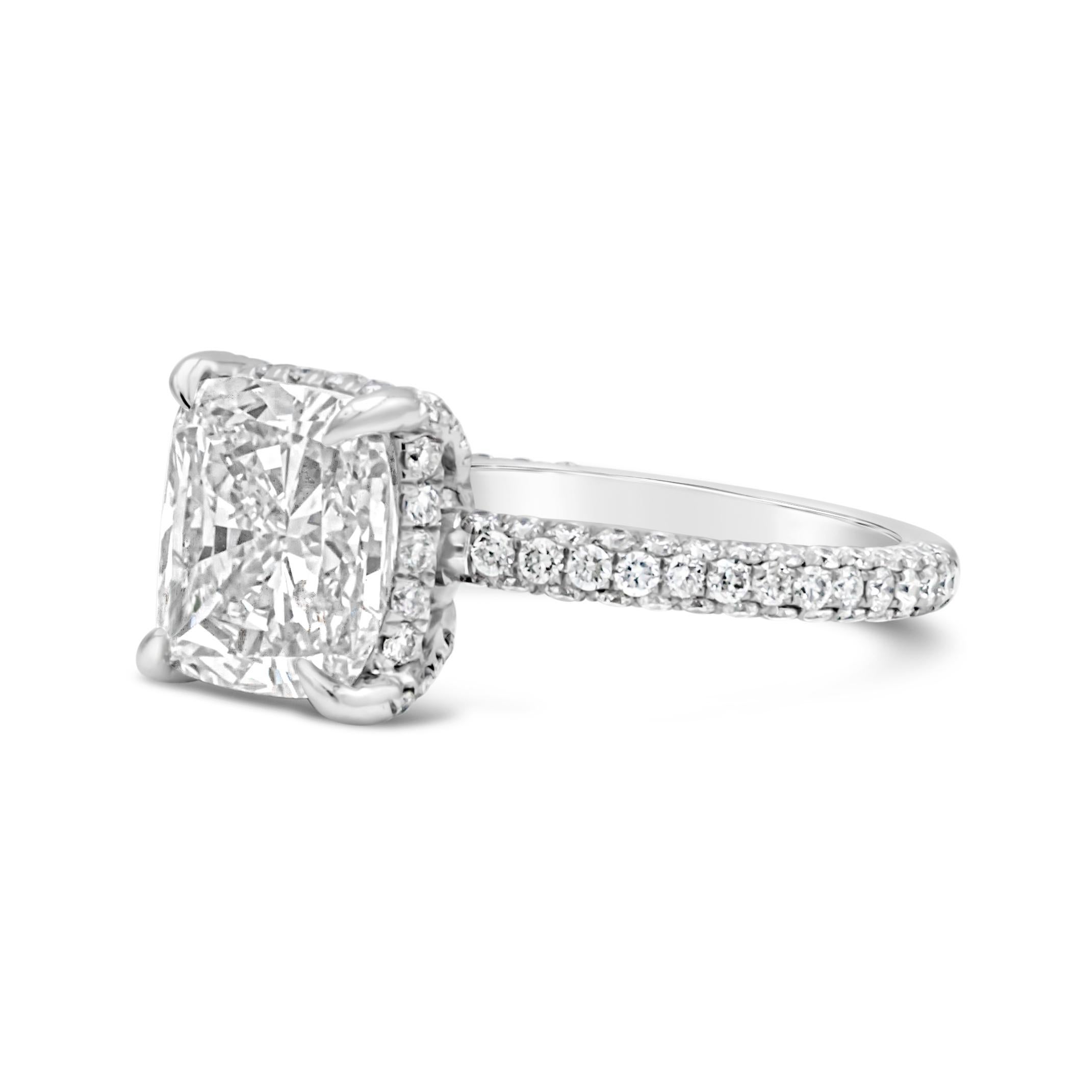 An elegant engagement ring, showcasing a 3.01 carats cushion cut diamond certified by GIA as J color and I1 clarity, set on a classic four prong setting. Accented by 120 round brilliant cut diamonds weighing 0.85 carat total, set on a scalloped pavé