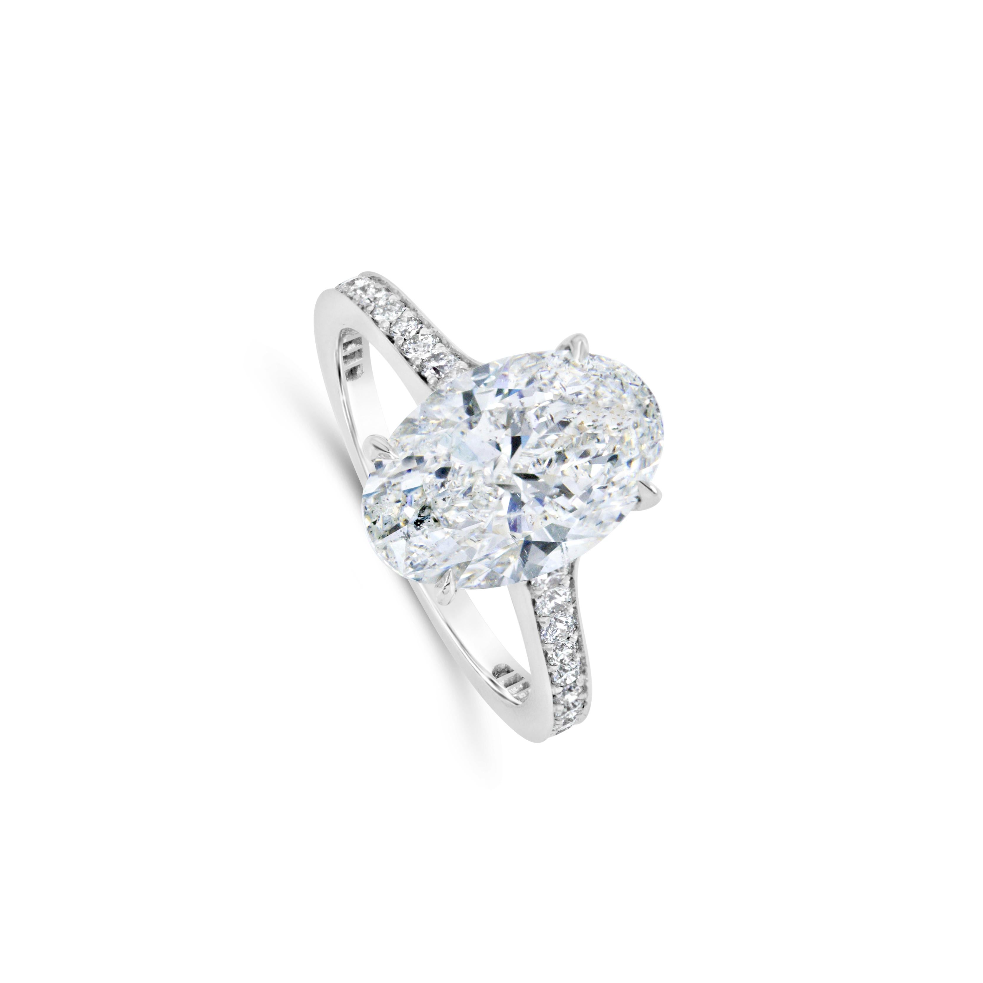 Ein prächtiger Verlobungsring mit einem oval geschliffenen Diamanten von 3,61 Karat, der von GIA mit der Farbe F und der Reinheit SI2 zertifiziert wurde und in einer klassischen vierzackigen Fassung gefasst ist. Akzentuiert durch Diamanten im