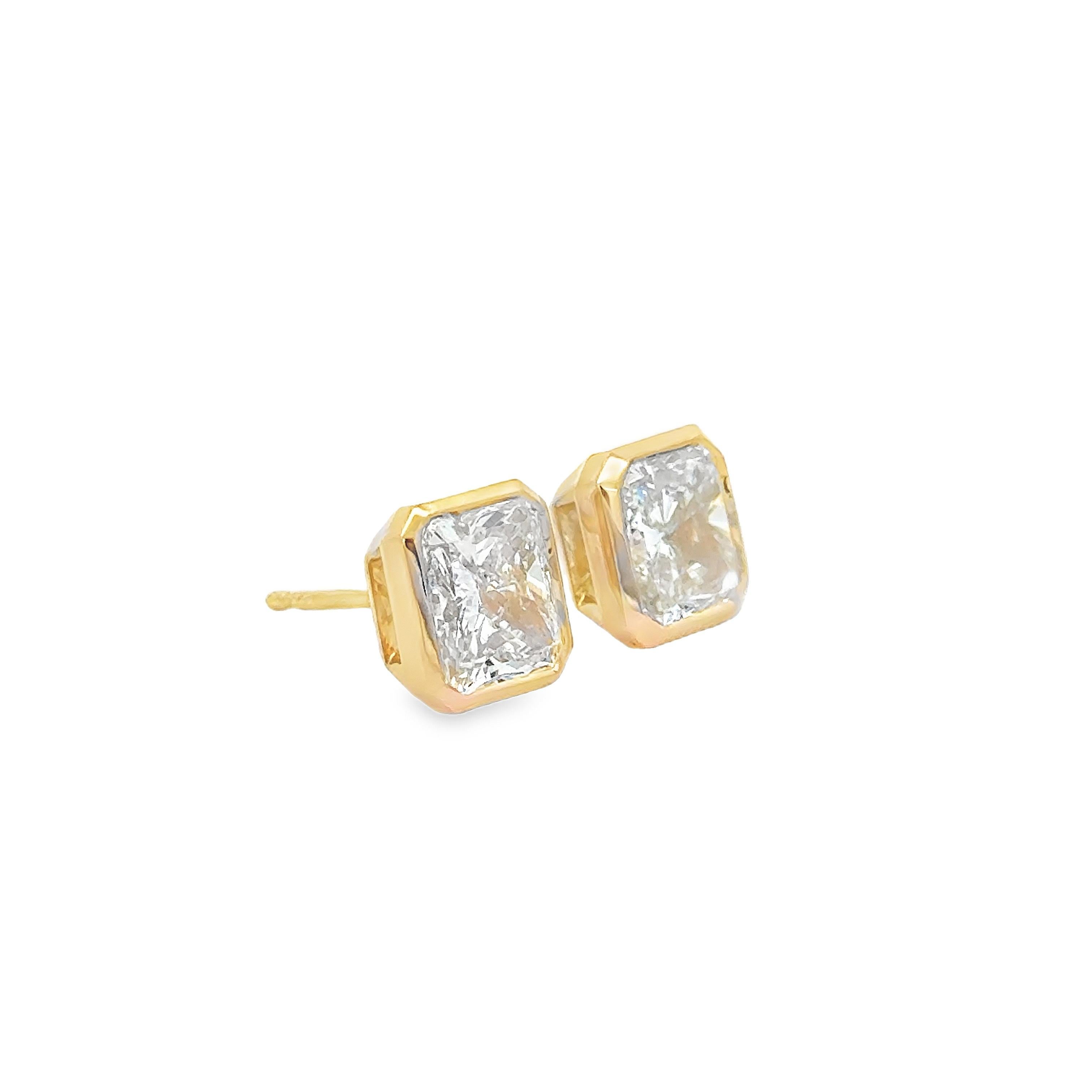 Maravilloso par de pendientes, con diamantes de talla radiante de 2,04 y 2,00 quilates, certificados por el GIA como de color L-M y claridad VS-VVS, respectivamente. Los diamantes están engastados en bisel en oro amarillo de 18 quilates. Perfecta