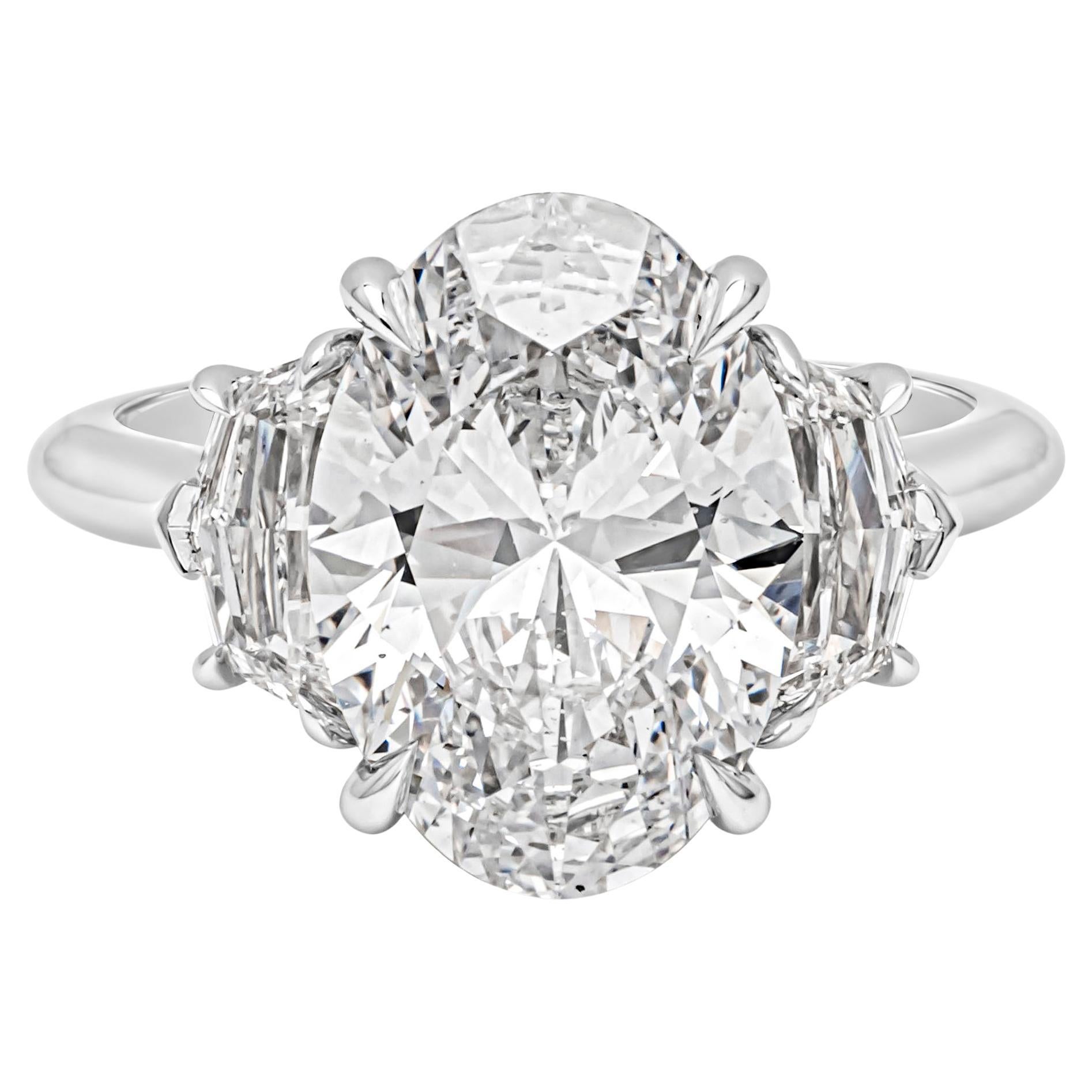 Elegantly made three stone ring featuring an oval cut diamond weighing 5.11 carats flanked by two epaulet diamond on each side, weighing 1.02 carats total, D-E color and VS in clarity. GIA certified the center diamond as D color, SI1 in clarity and