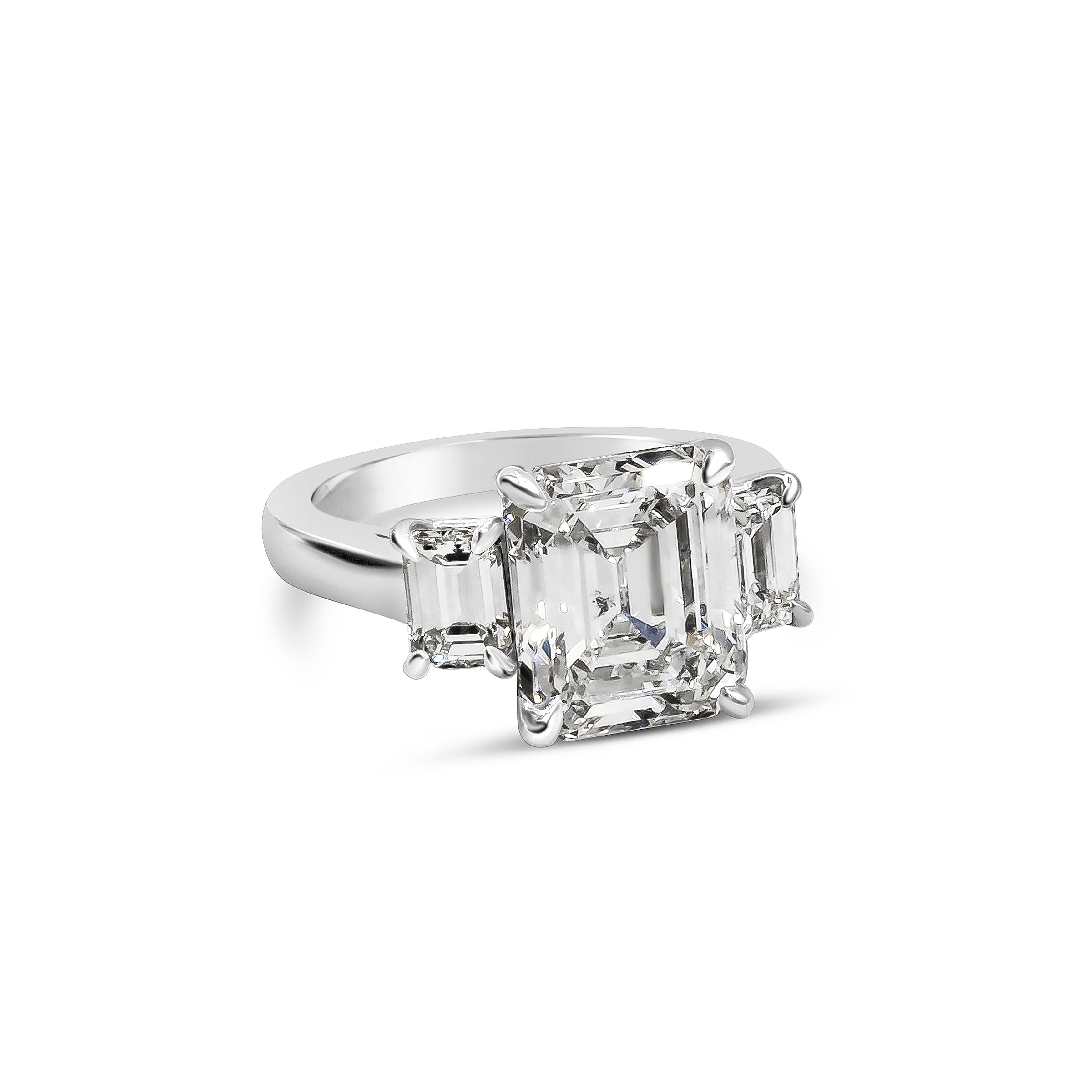 A sophisticated and subtle engagement ring style showcasing a 5.16 carats emerald cut diamond certified by GIA as H color and SI2 in clarity, set in four prong platinum. Flanked by smaller emerald cut diamonds on each side, weighing 1.11 carats