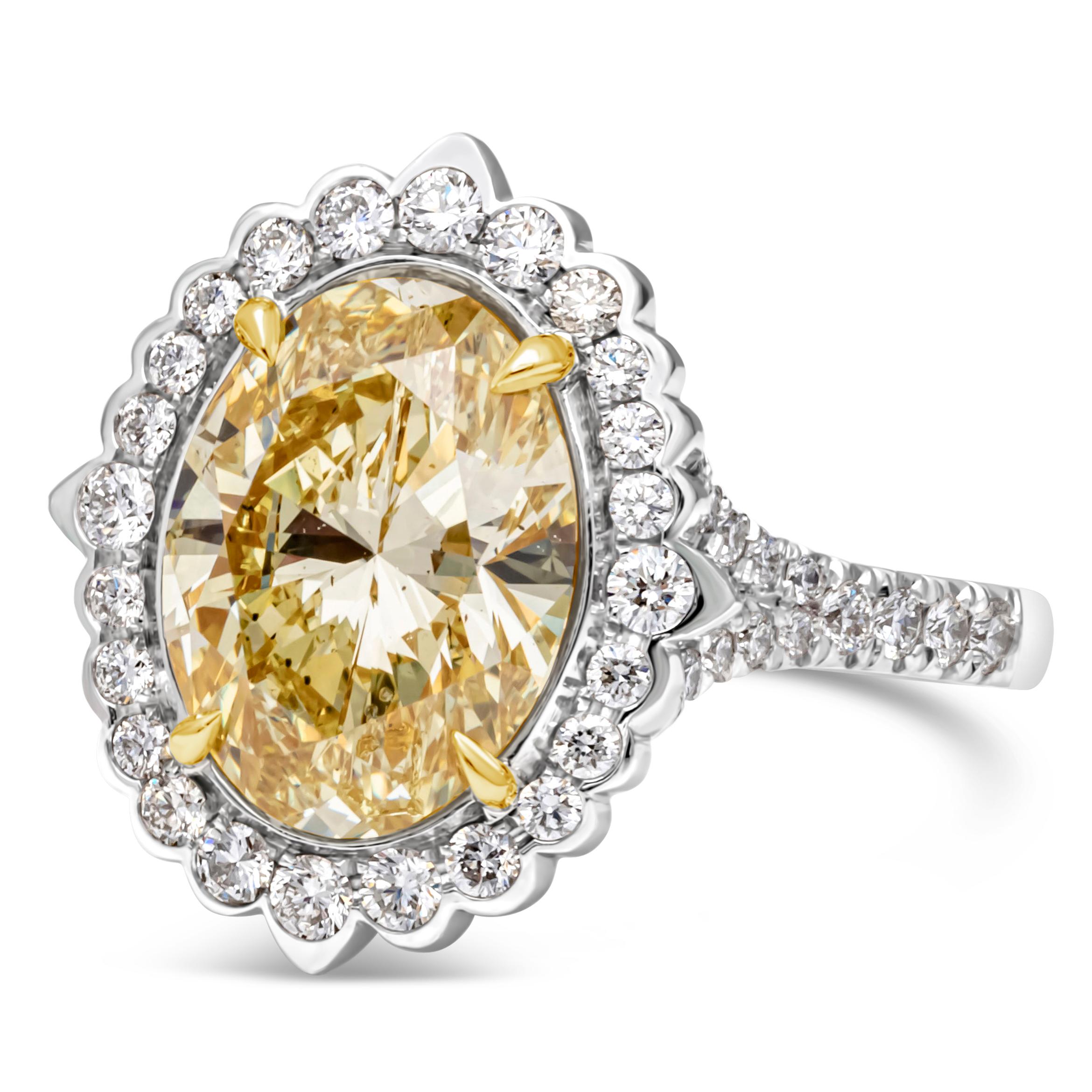 An elegant and vibrant halo engagement ring, featuring an oval cut diamond of 3.39 carats and certified by GIA as fancy intense yellow color and SI1 clarity, set in a four prong 18K yellow gold basket setting. The center stone's color is very strong