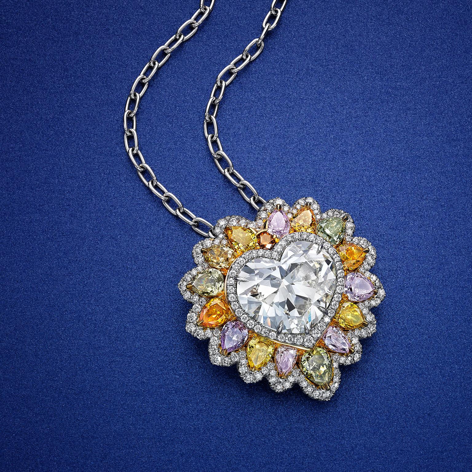 Rare and well-crafted pendant necklace showcasing a GIA certified 10.02 carat heart shape diamond, set in a beautiful and colorful lion's mane halo made in different color diamonds. Finished with a single row of round brilliant diamonds on the edge