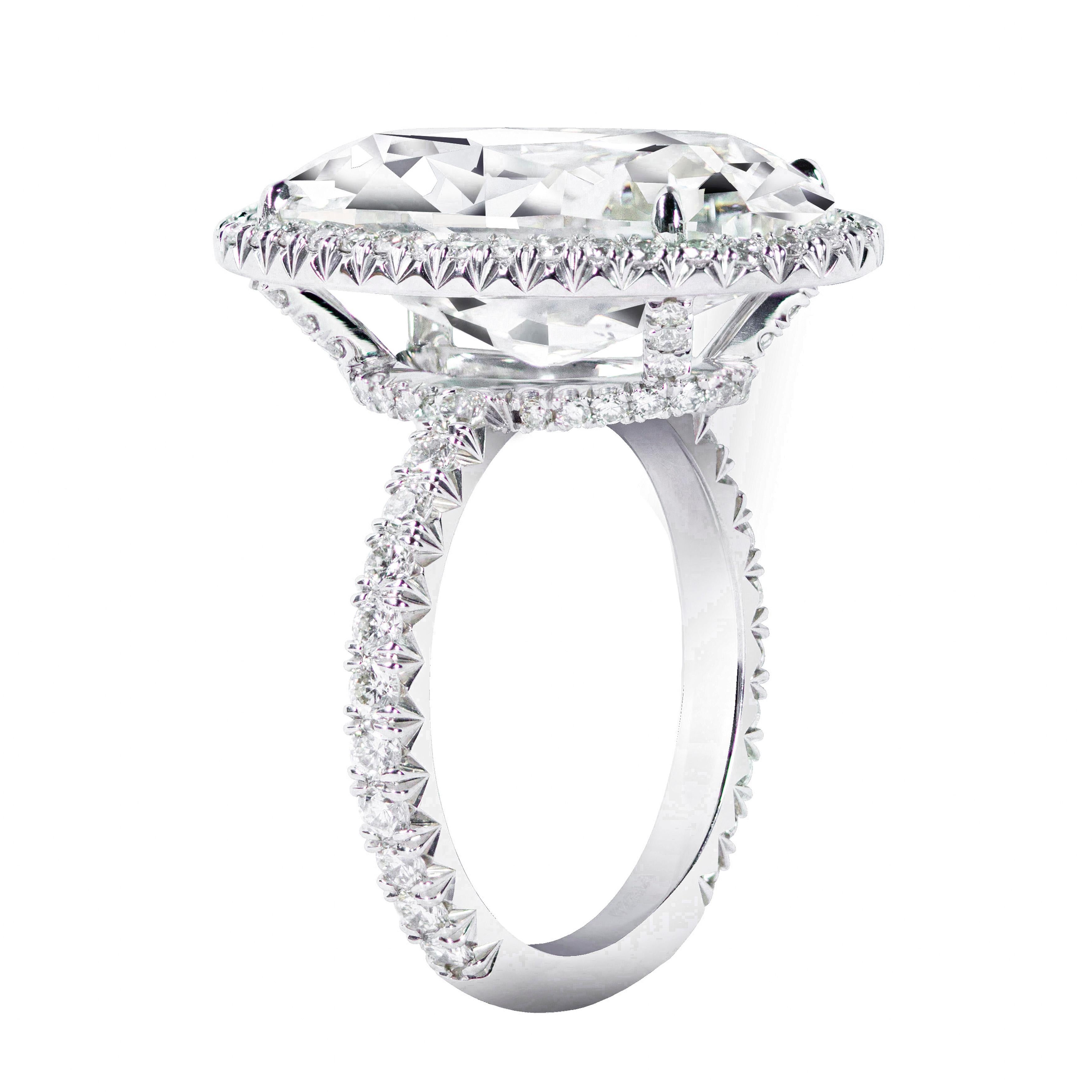 Elegantly made engagement ring features a 10.09 carats oval cut diamond center stone certified by the GIA as J color and SI2 in clarity. Set in a four prong diamond encrusted basket halo setting made in platinum. Shank is encrusted with brilliant