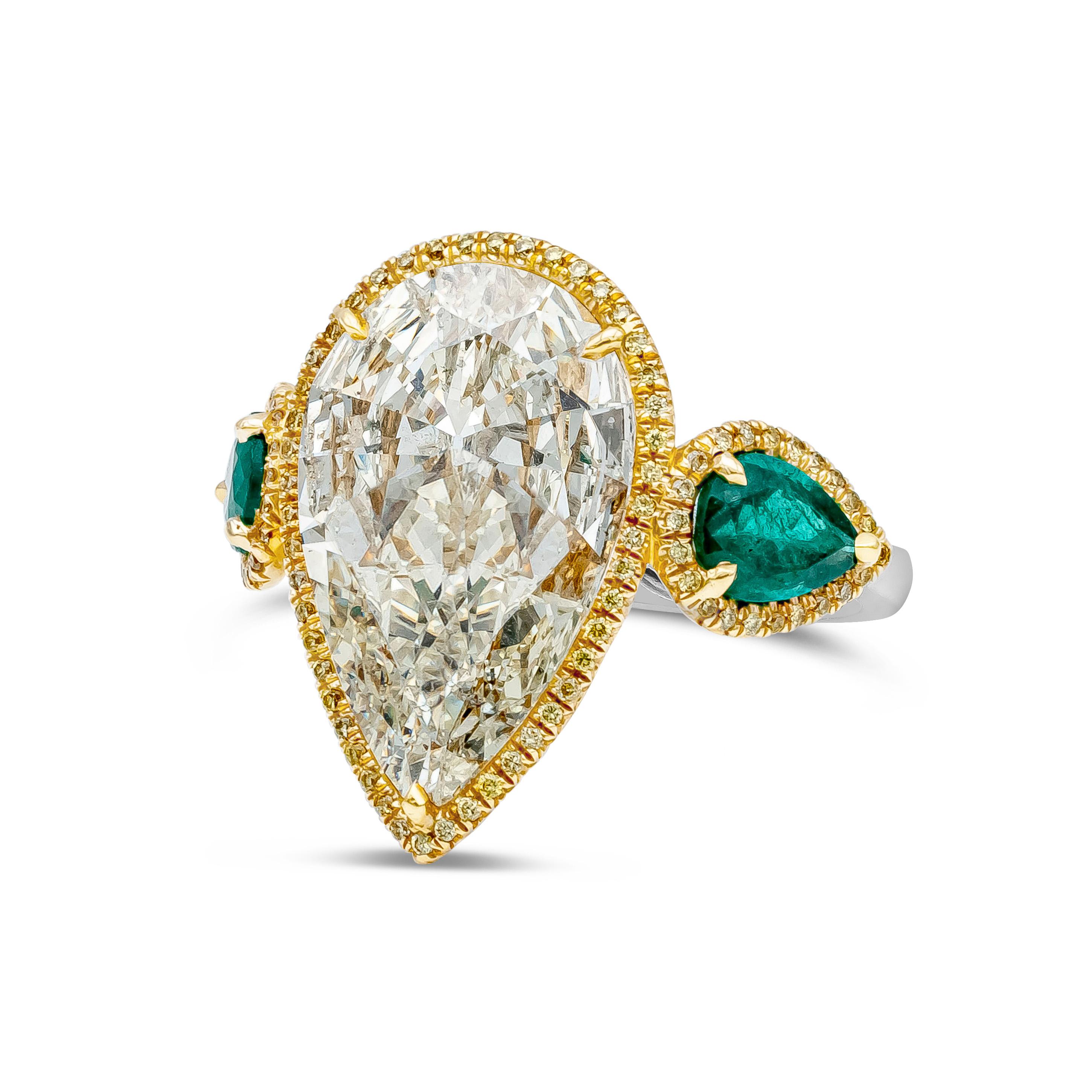 A unique engagement ring, showcasing a 6.65 carats pear shape diamond certified by GIA as M color and SI2 clarity, set on a three prong setting. Flanked by pear shape emeralds weighing 1.41 carats total. Each stone is embellished with a single row