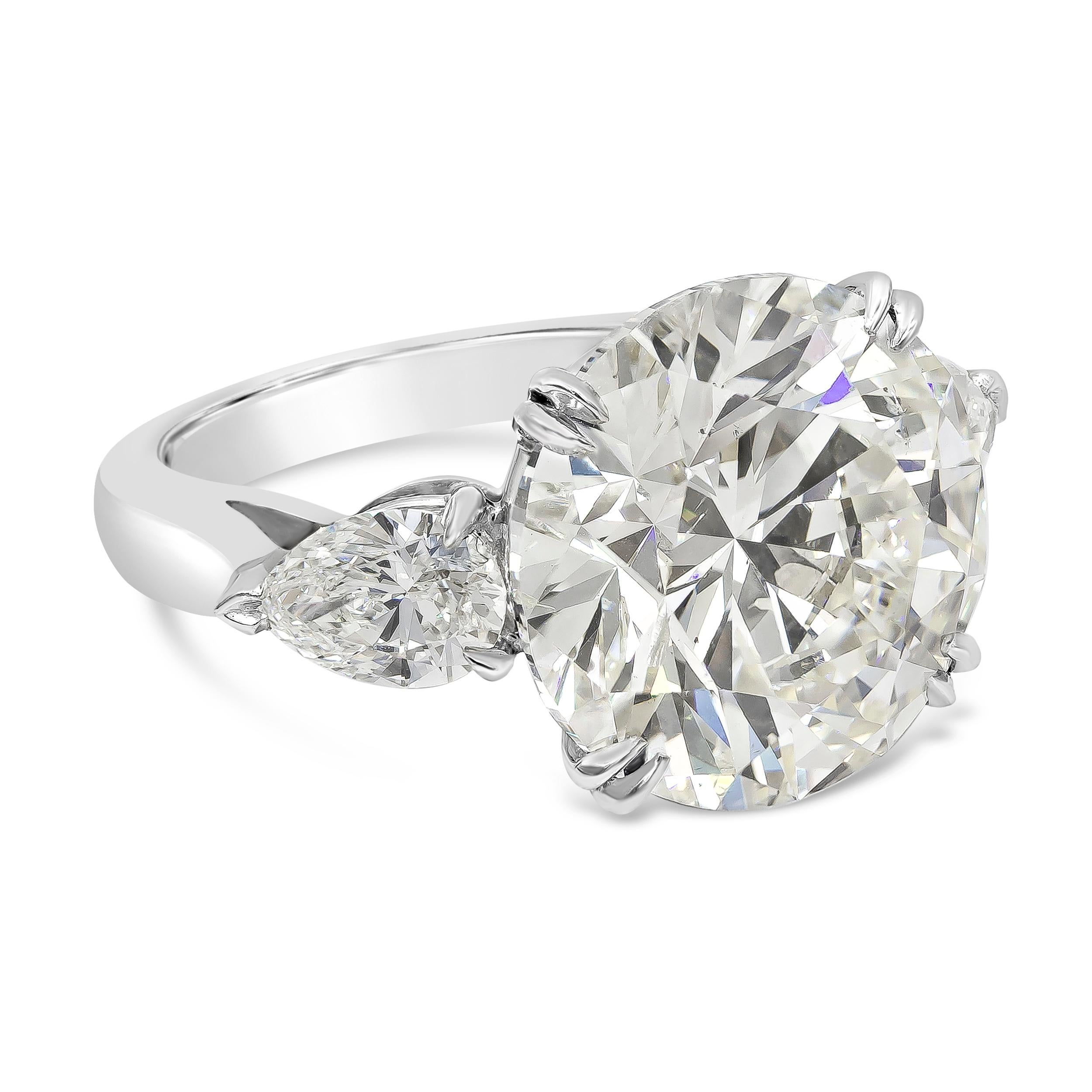 This gorgeous and important engagement ring features a 10.09 carat brilliant round shape diamond that is GIA Certified as K color and SI2 in clarity, flanked by pear shape diamonds on each side weighing 1.22 carats total. Finely made in platinum.