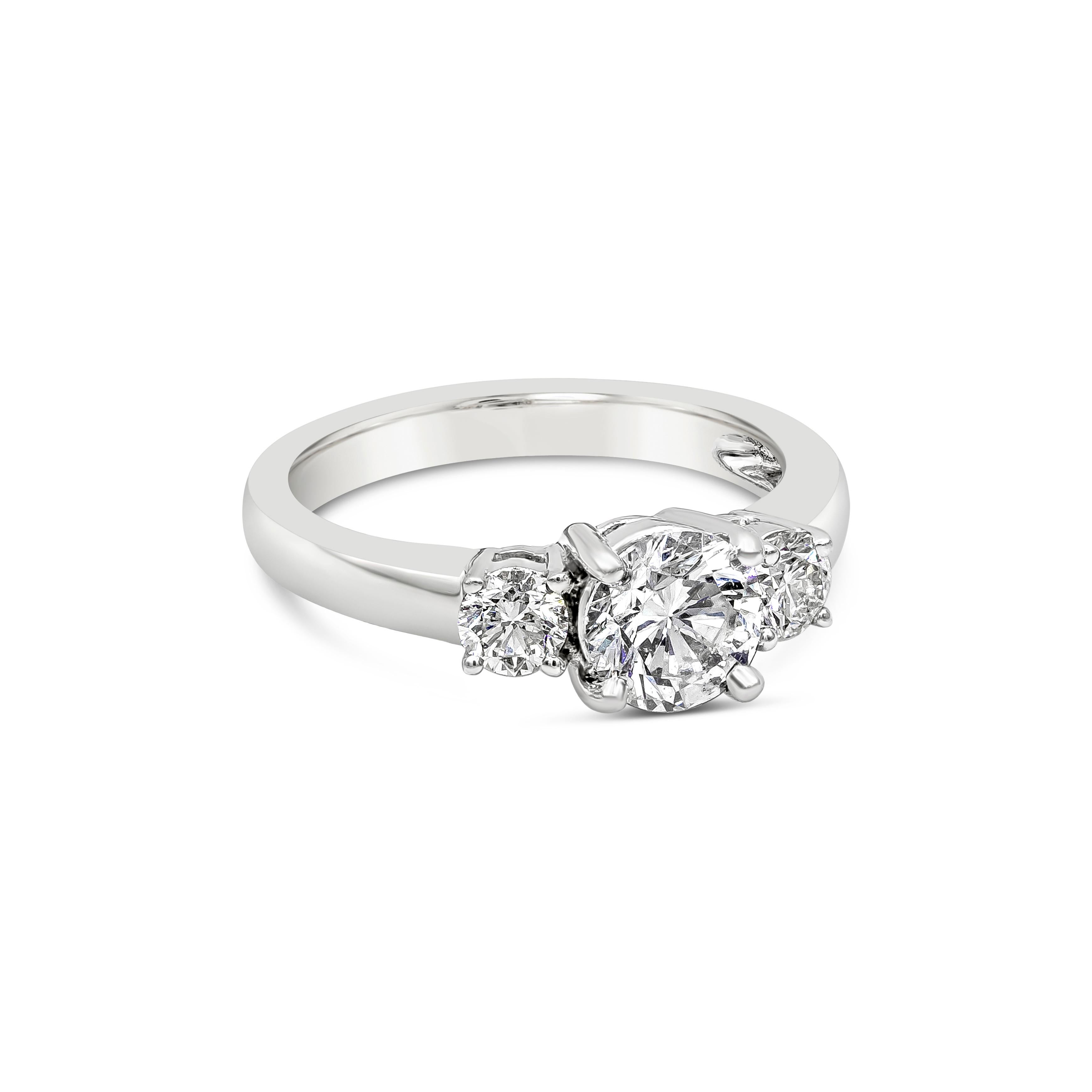 A luxurious round diamond three-stone engagement ring will always be timeless. This ring showcases a GIA certified center stone that weighs at 1.02 carat. Round diamond is certified with D color and SI2 clarity. Flanked by a smaller brilliant round
