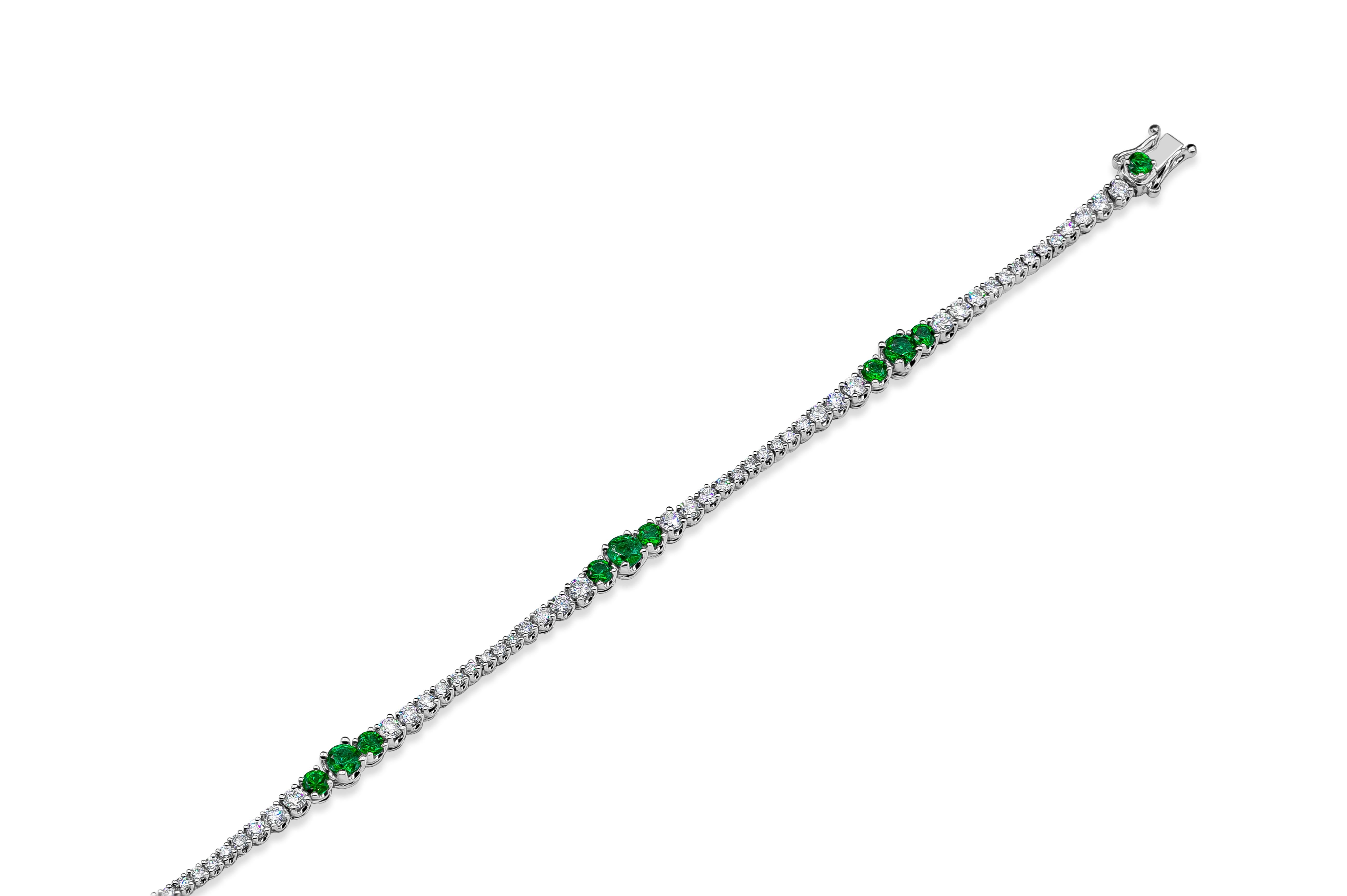 Classic tennis bracelet featuring a row of round brilliant diamonds, spaced by three-green emeralds equidistant from each other. Diamonds weigh 1.87 carats total; emeralds weigh 1.36 carats total. Made in 18k white gold.

Style available in