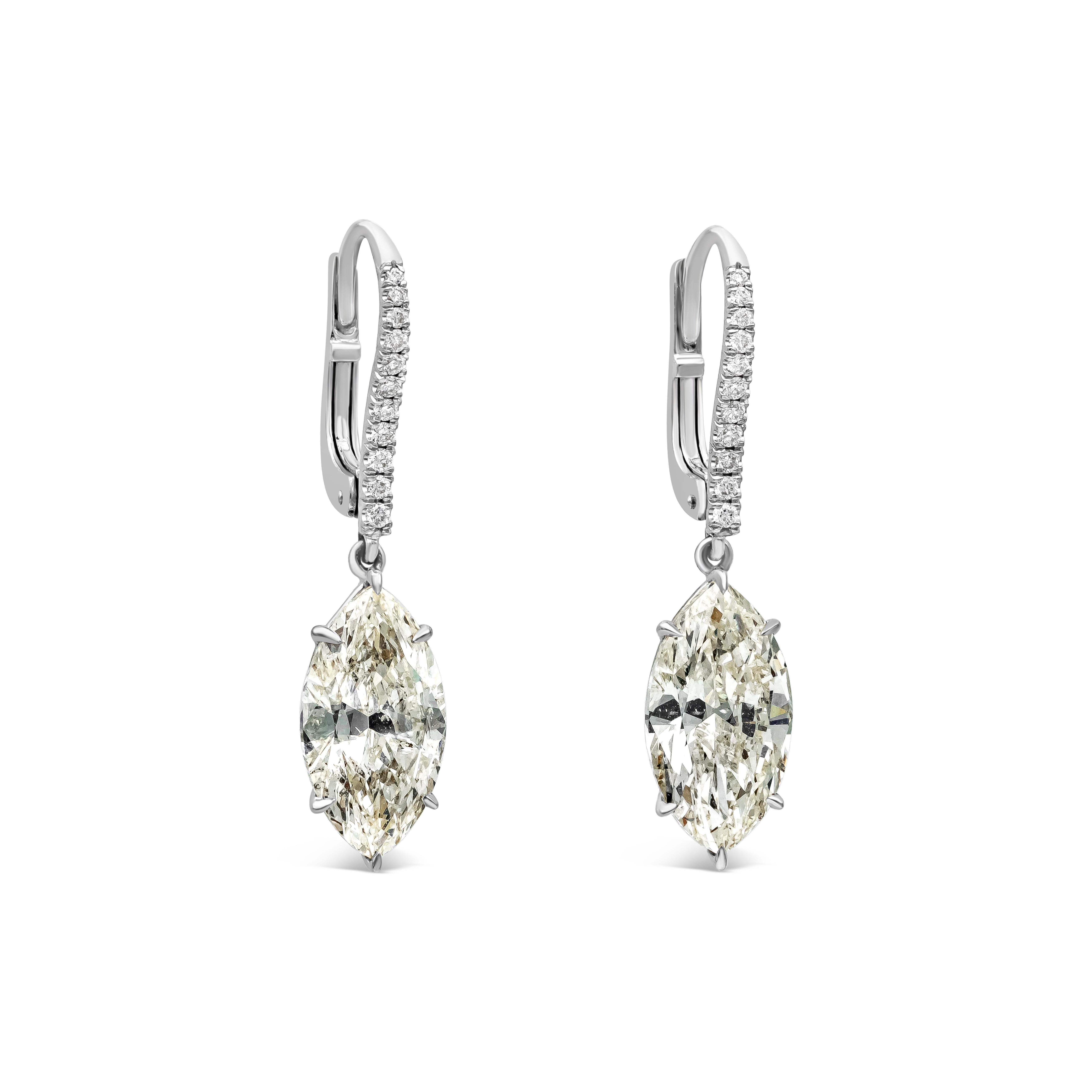 This beautiful pair of dangle earrings showcases two marquise cut diamonds weighing 6.69 carats total, L color, SI3-SI1 in clarity. Both hanging by a brilliant round diamond encrusted lever. 22 brilliant round diamonds weigh 0.23 carats total. Made
